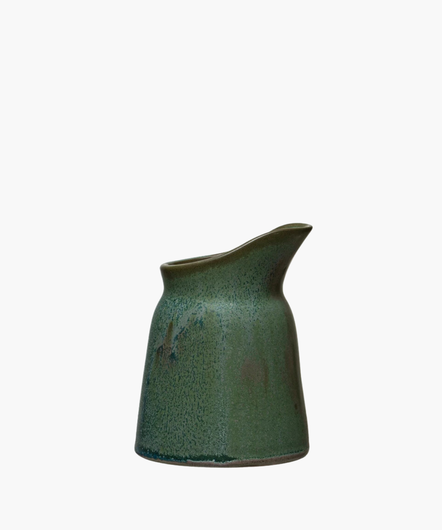 Green glazed ceramic creamer with a smooth, speckled texture and a curved spout. The design is modern and minimalist, evoking calm and simplicity. | Wildwood Home Co.