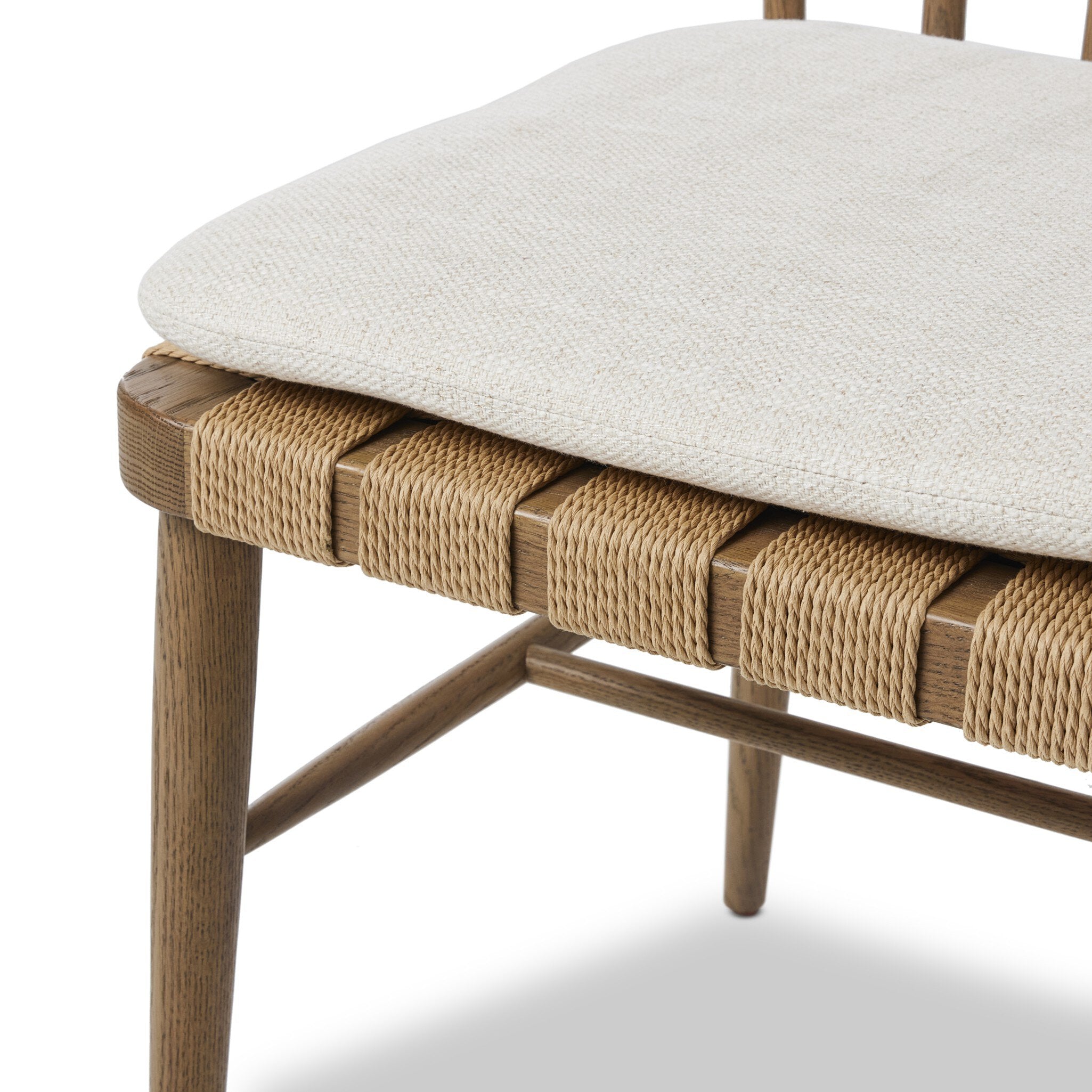 Close-up of a chair with woven seat and white cushion on a white background