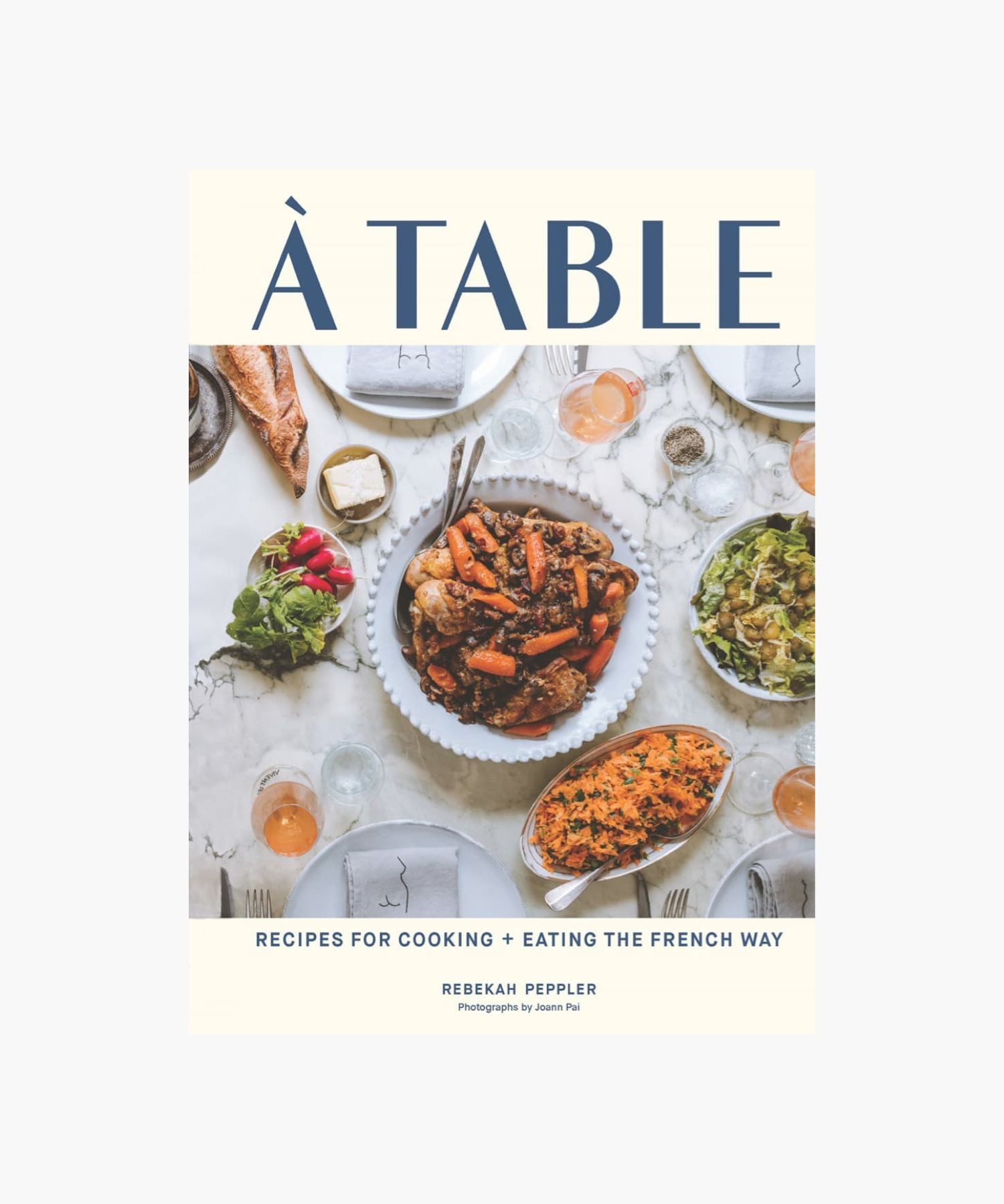 The cover of "À Table" by Rebekah Peppler features a French meal with dishes like roast chicken, carrots, salad, red wine, and bread on a marble table.