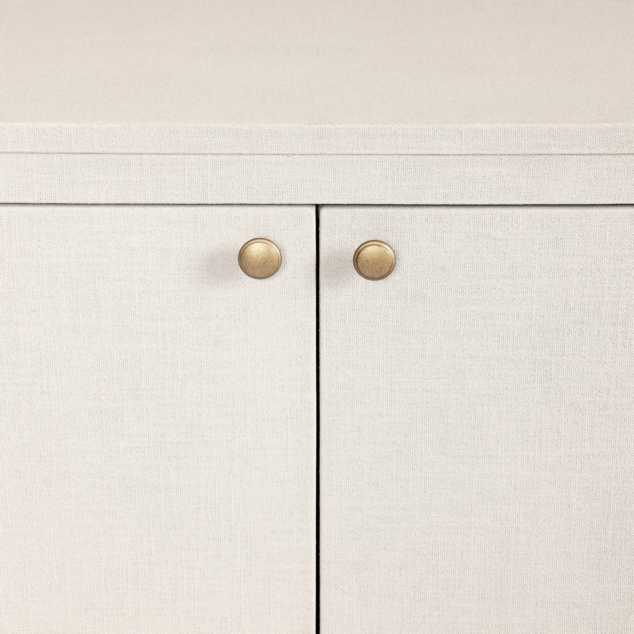 Close up of a white oval shaped sideboard cabinet with four doors on a white background.