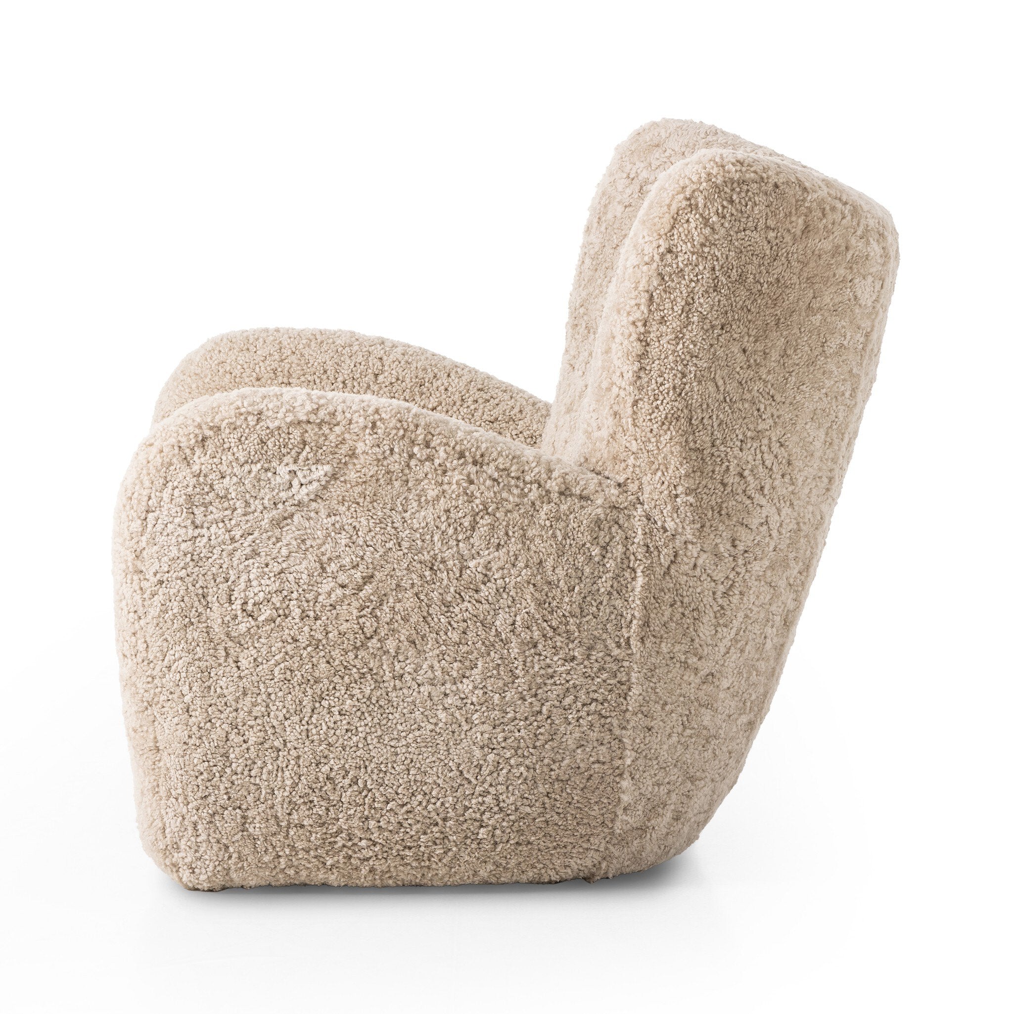 Side profile of a natural beige shearling armchair on a white background.