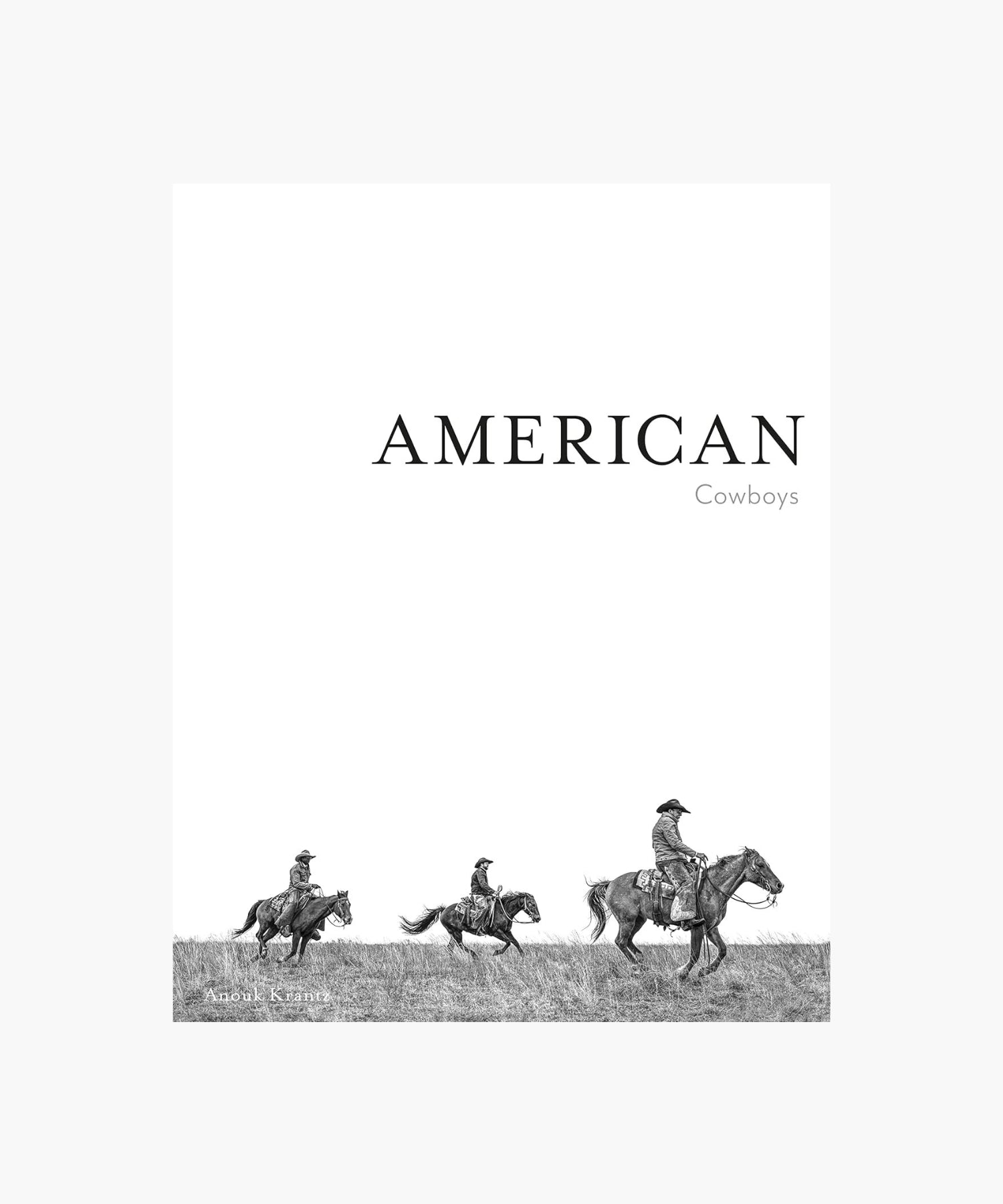 The cover of the book "American Cowboys" by Anouk Krantz features three cowboys on horseback, riding across a grassy field, conveying a sense of adventure and the American West. | Wildwood Home Co.