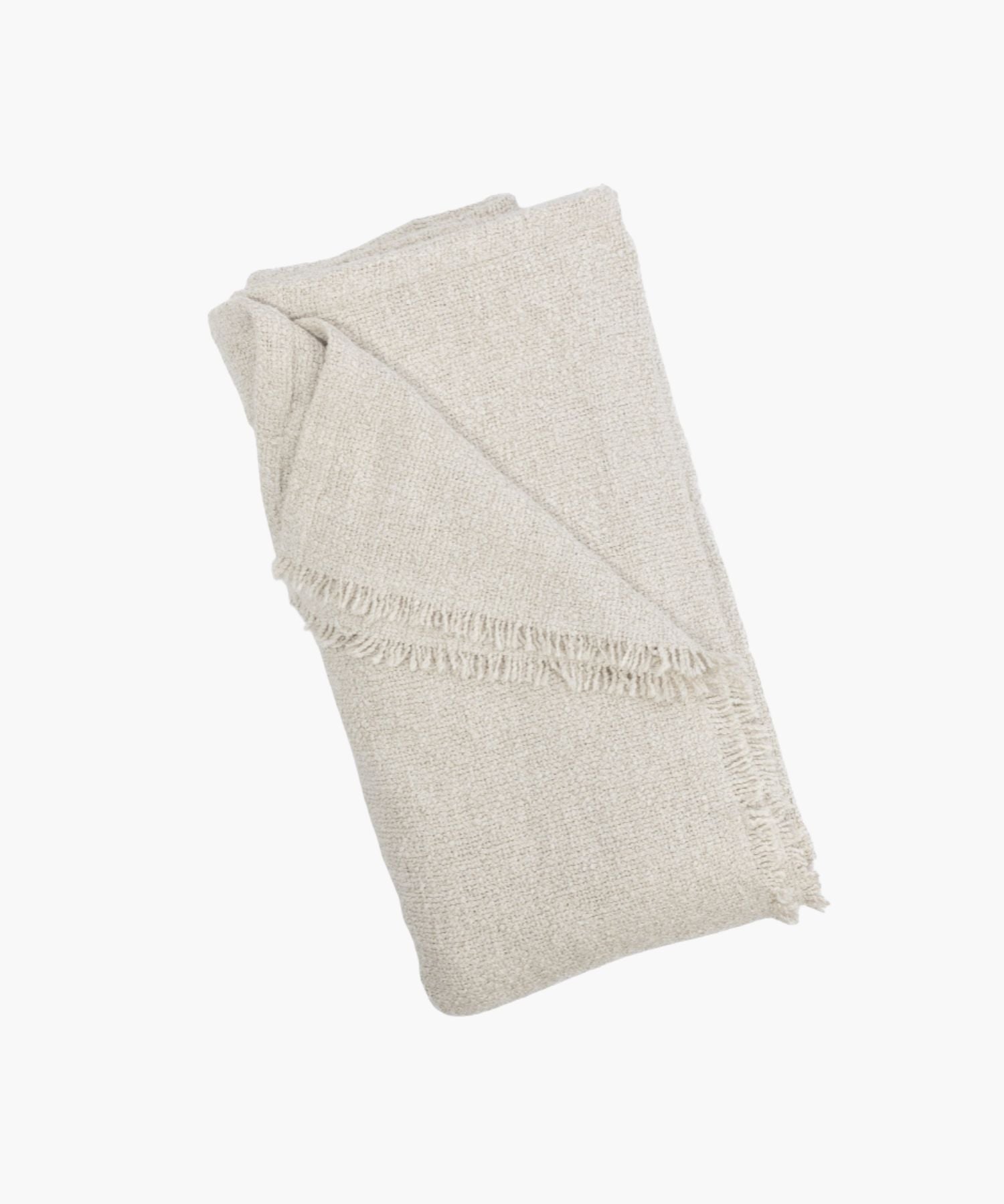 Folded cream coverlet with a boucle texture and short fringe detail at the edge. | Wildwood Home Co.