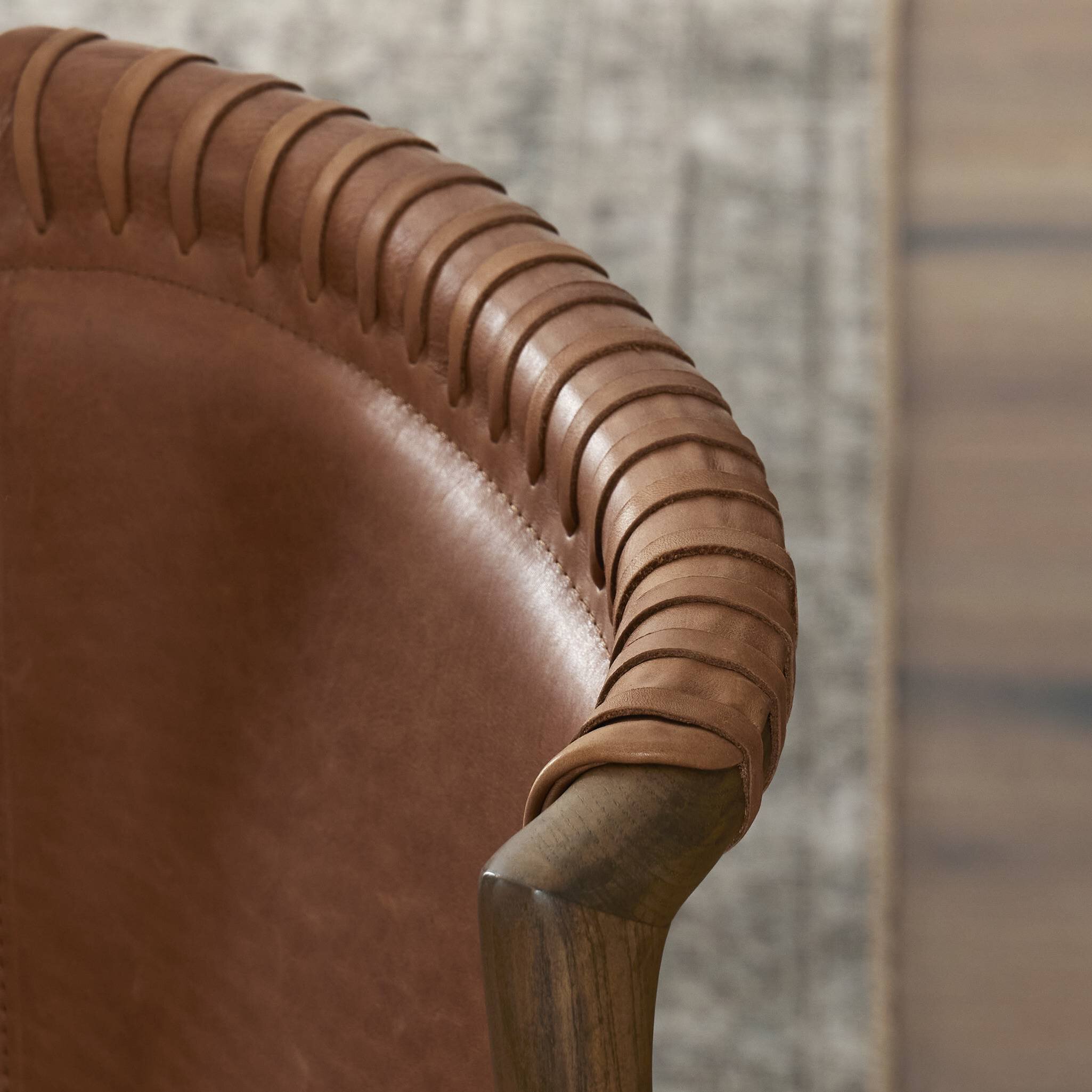 Close up of a tobacco-grain leather chair highlighting its leather wrap detailing.