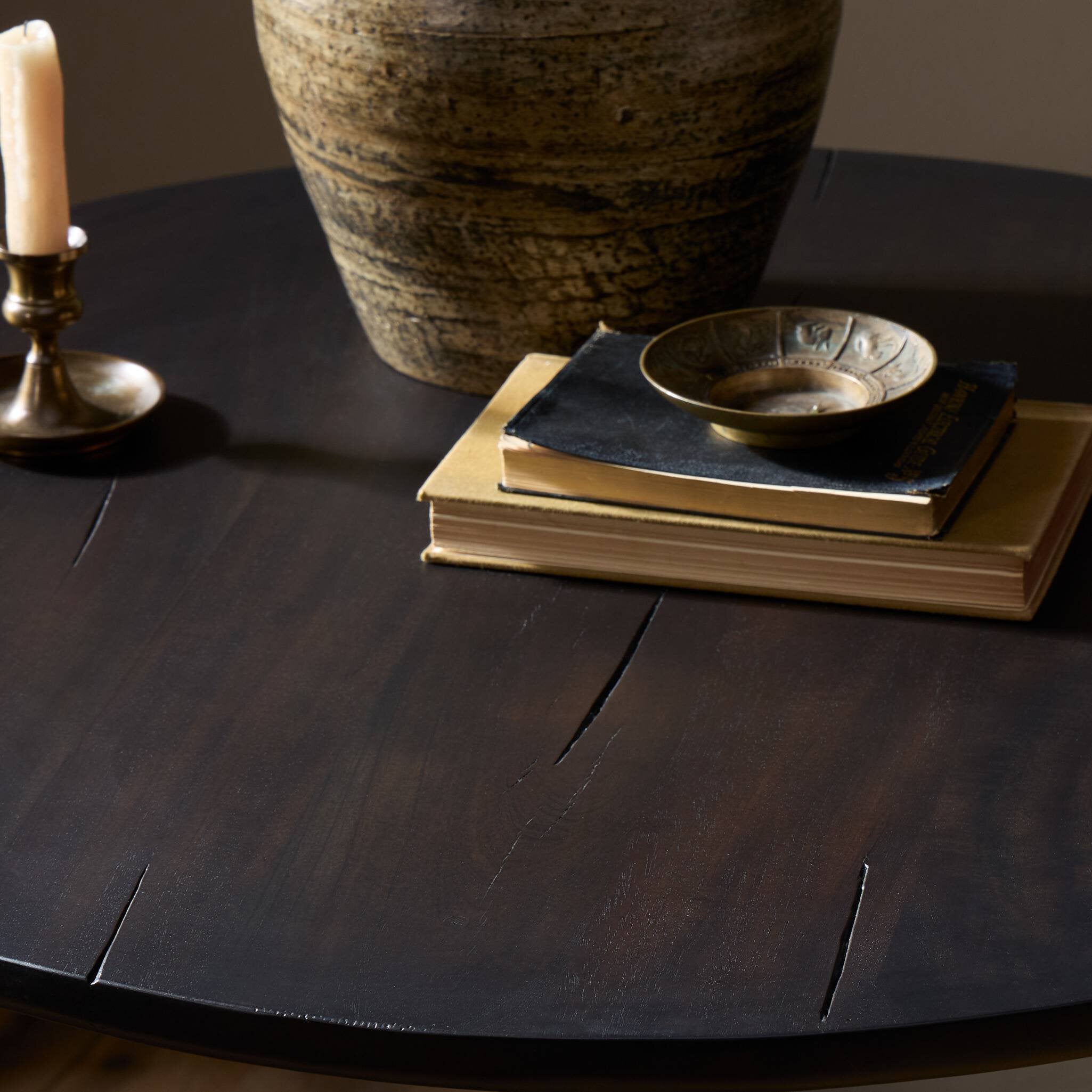 Dark wooden table with decorative items including a vase, books, and a candle.