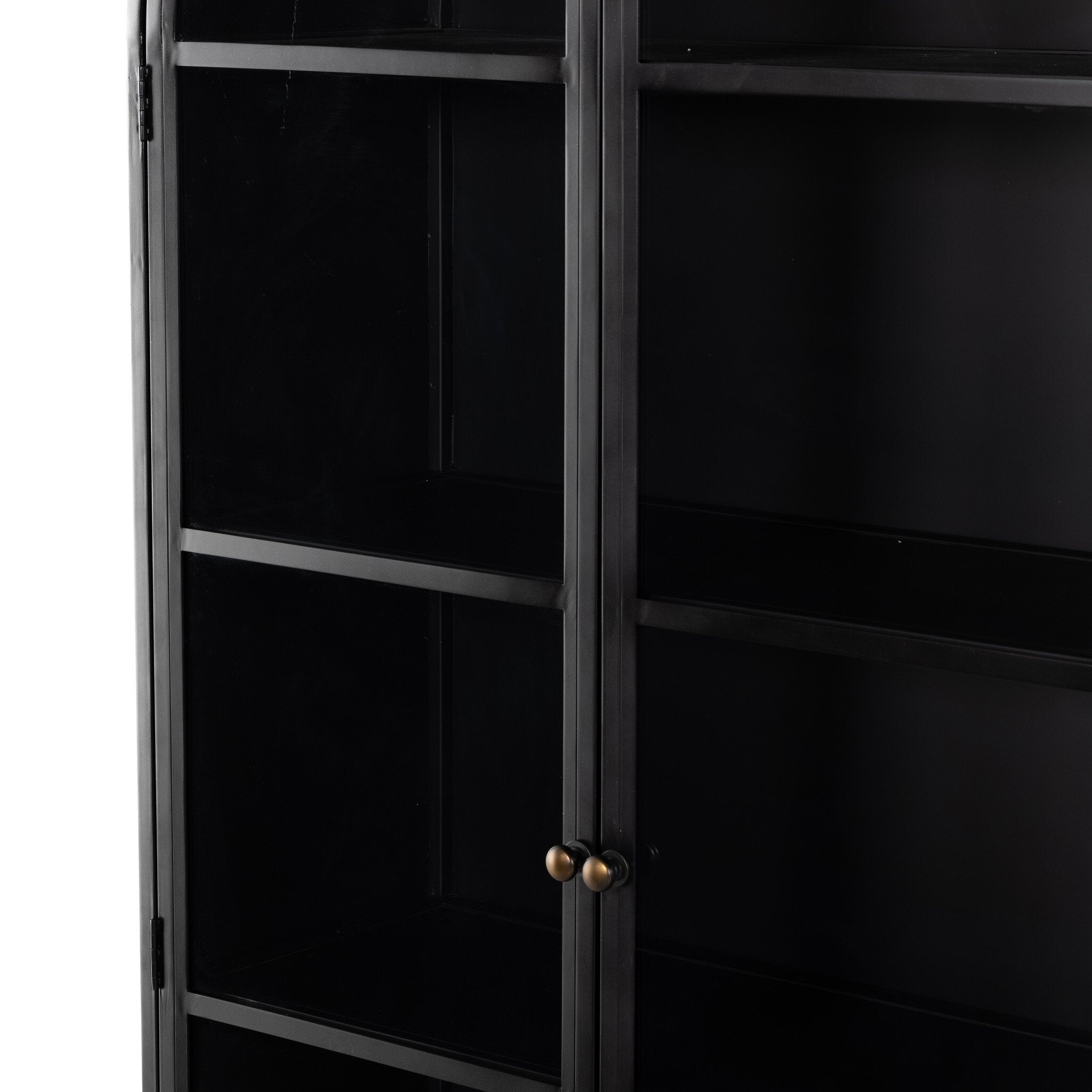 Close up of a black-finished iron arched cabinet with glass front doors.
