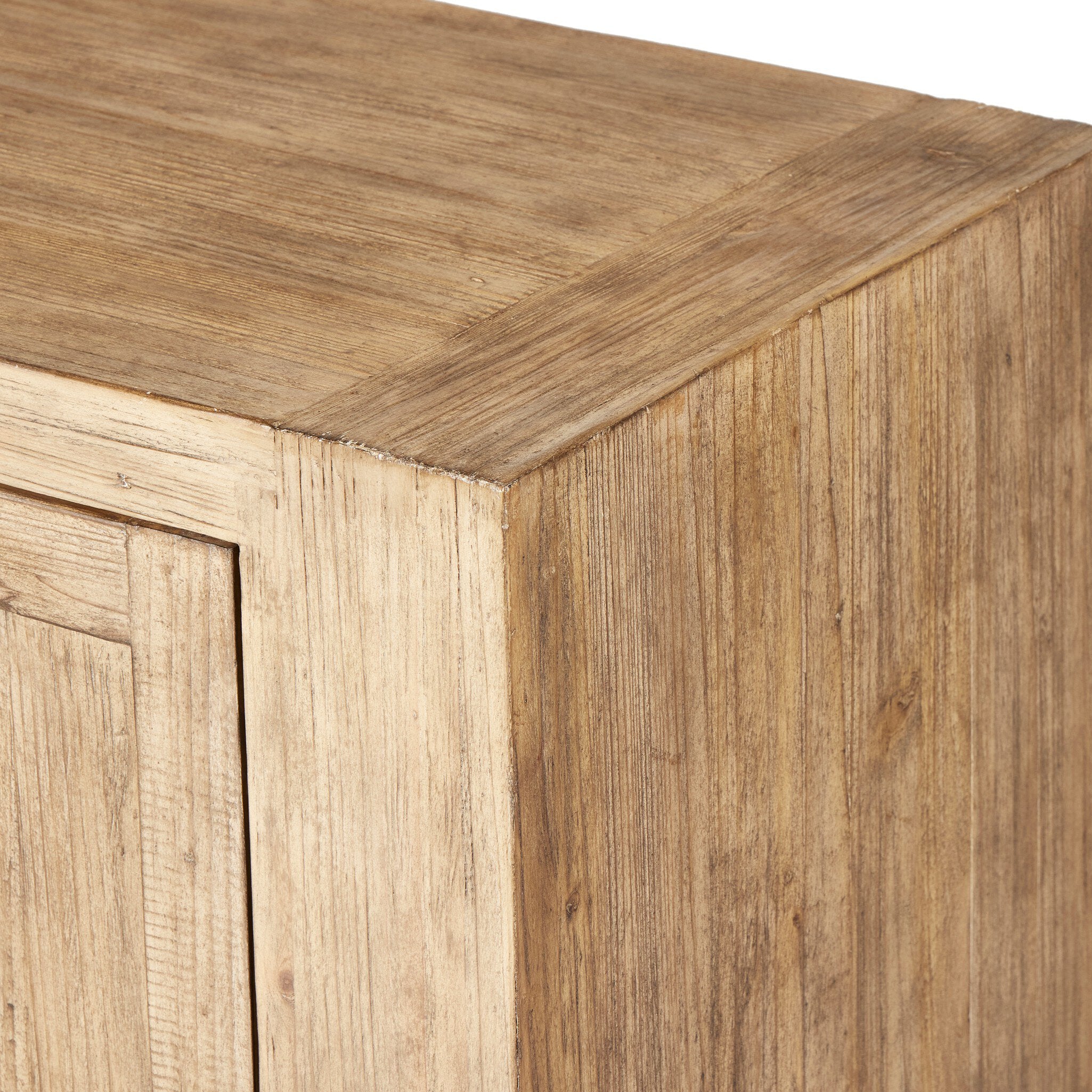 Close up of a wooden sideboard with four doors and three drawers in the center on a white background.