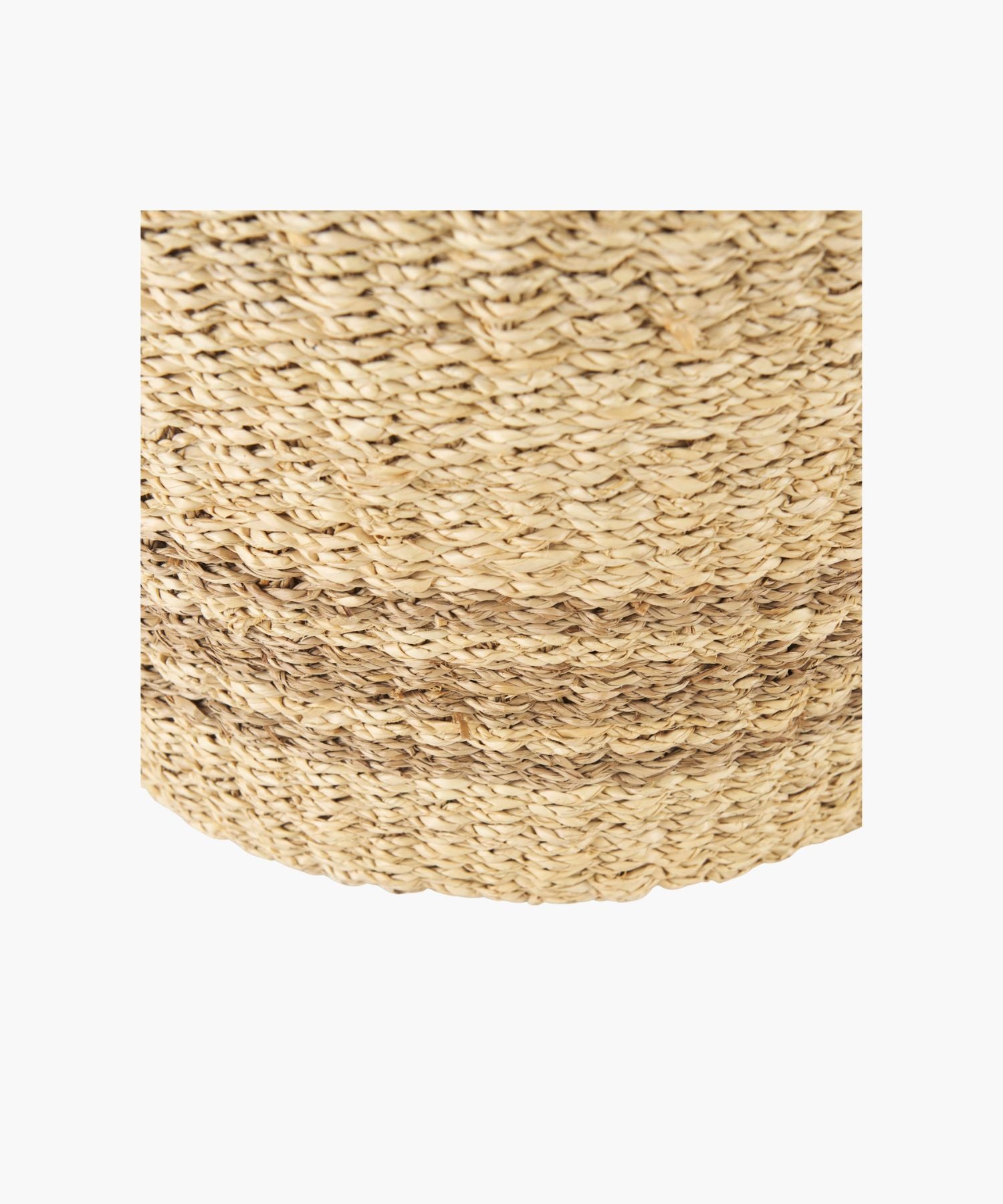 Close up of a woven seagrass basket in a natural and brown tone with two loop handles and subtle striped accents. The basket has a simple, rustic design.