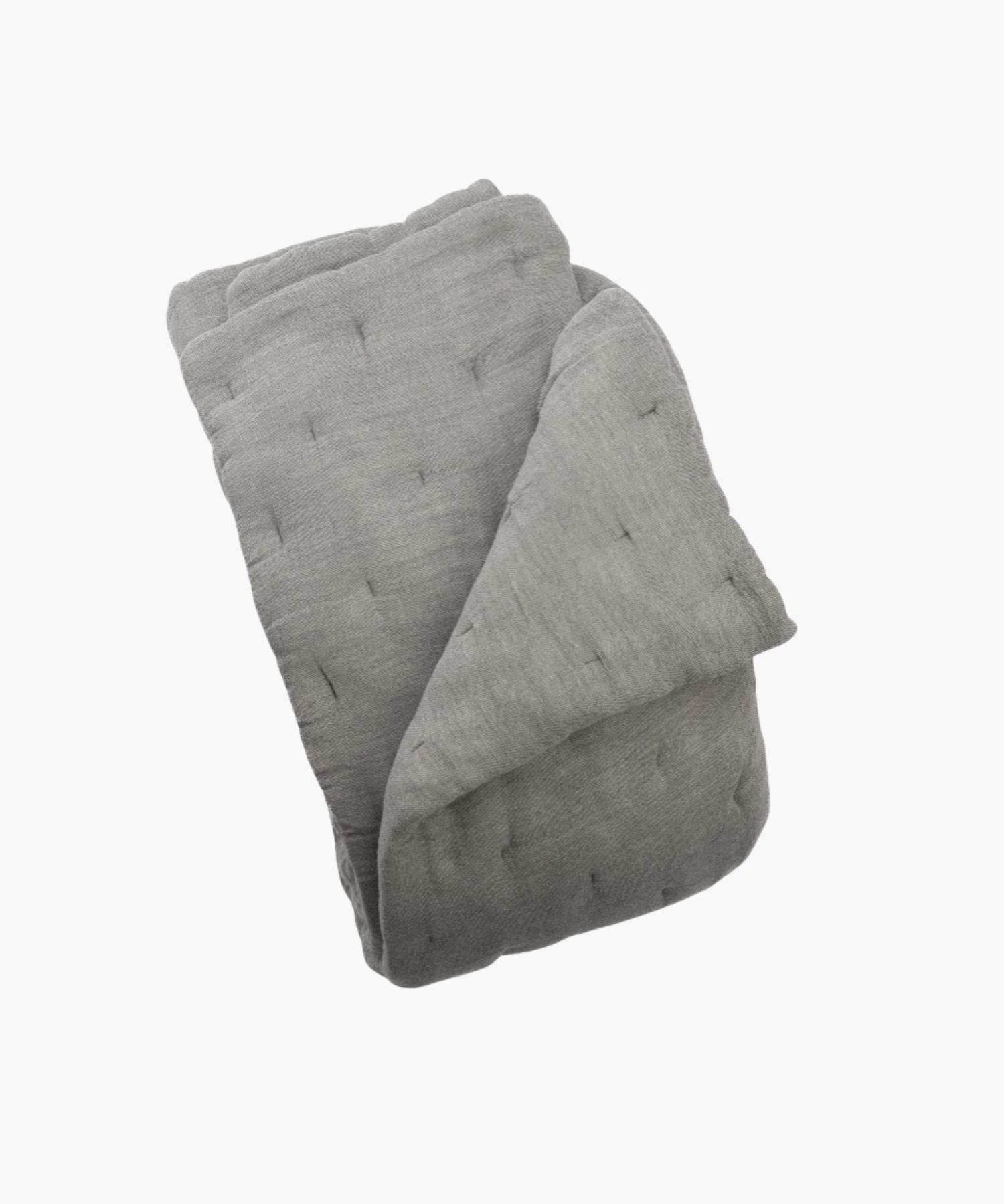Folded gray quilt on a white background showing its fabric texture. | Wildwood Home Co.