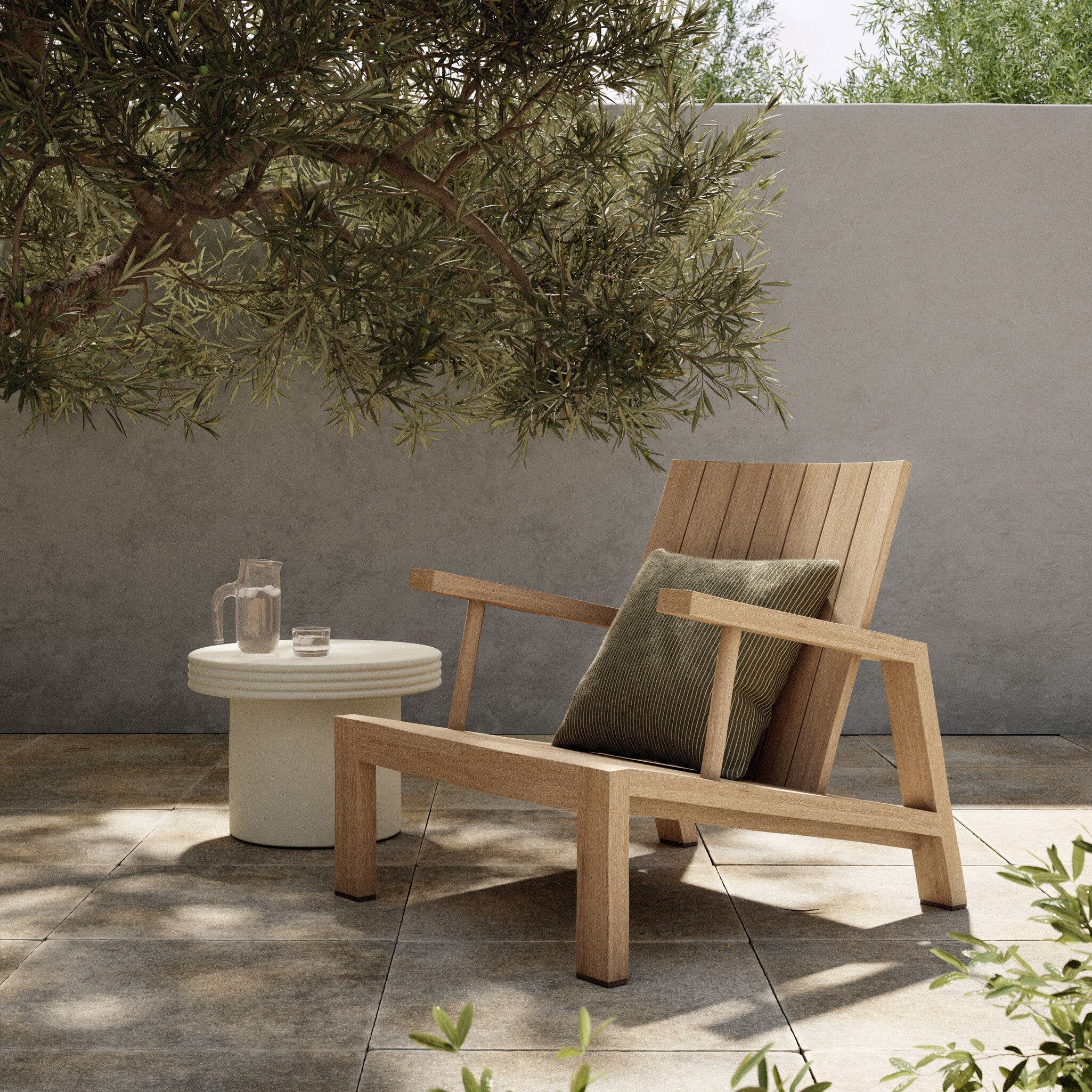 Wooden outdoor chair with a cushion on a patio with a small table and plants. | Wildwood Home Co.