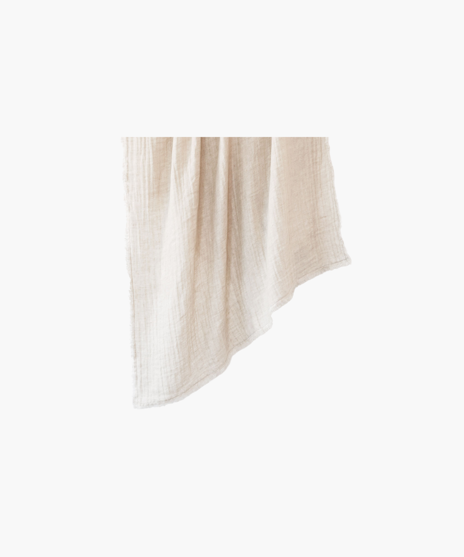 A soft, beige linen throw blanket is neatly hanging against a plain background, showcasing a delicate fringe along the edges, conveying a cozy and elegant feel. | Wildwood Home Co.