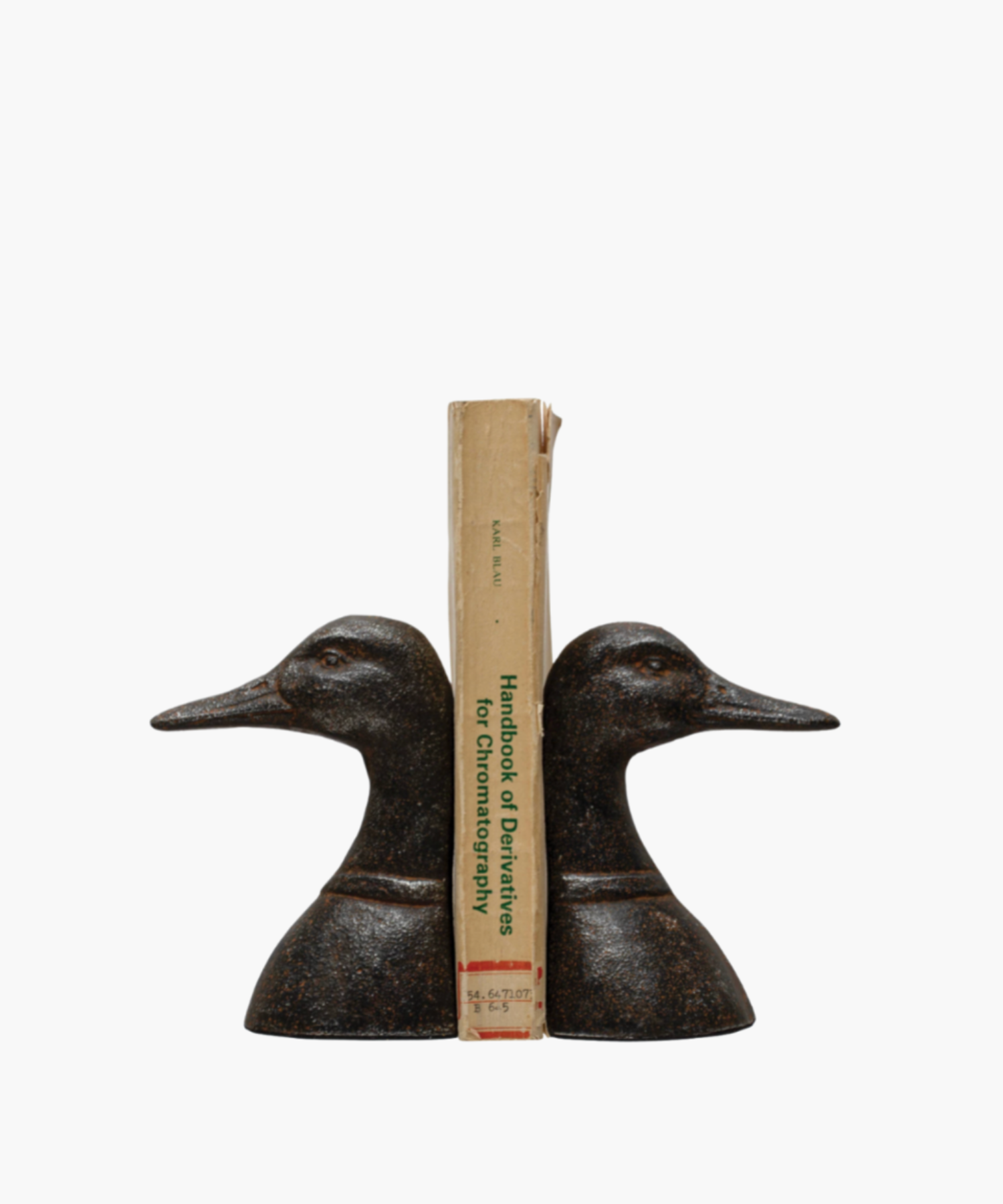 Two bronze duck head bookends face opposite directions with a book in the middle against a white background. They feature detailed textures, conveying a classic and elegant tone.