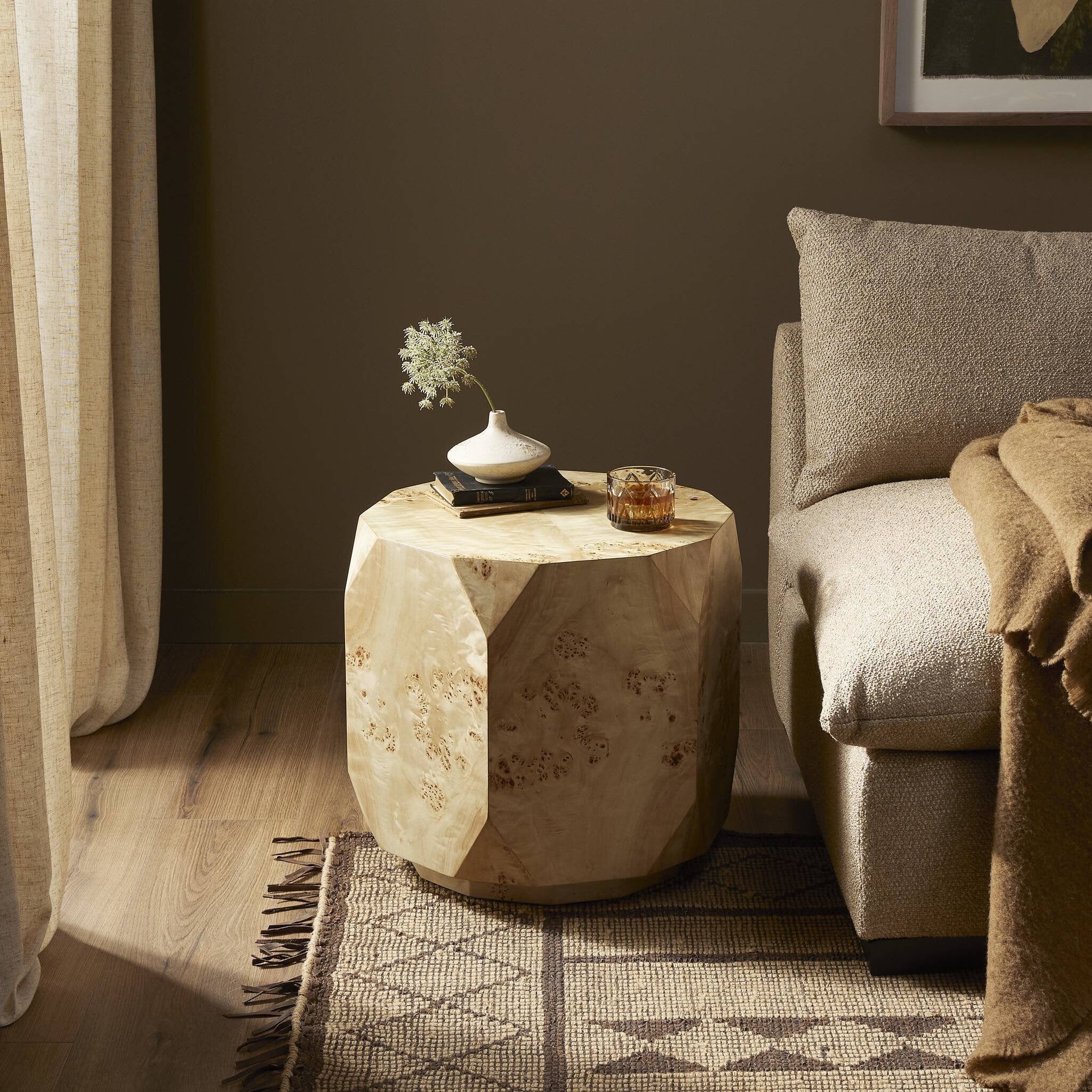 Wooden side table with decorative items next to a sofa in a living room. | Wildwood Home Co.