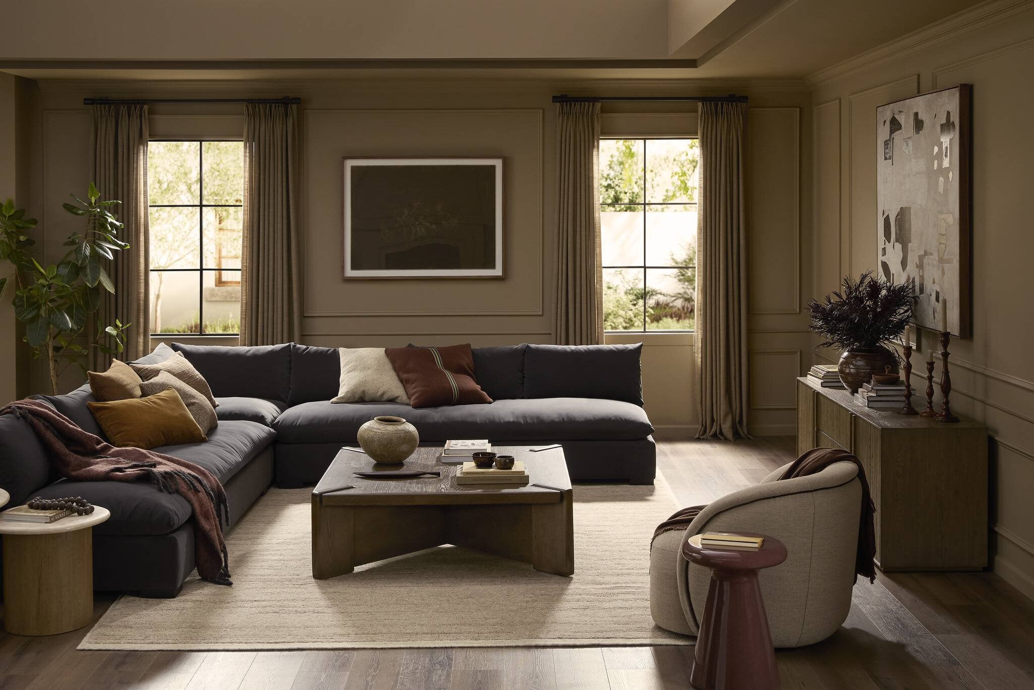 Modern living room with a sectional sofa, coffee table, and decorative items. | Wildwood Home Co.