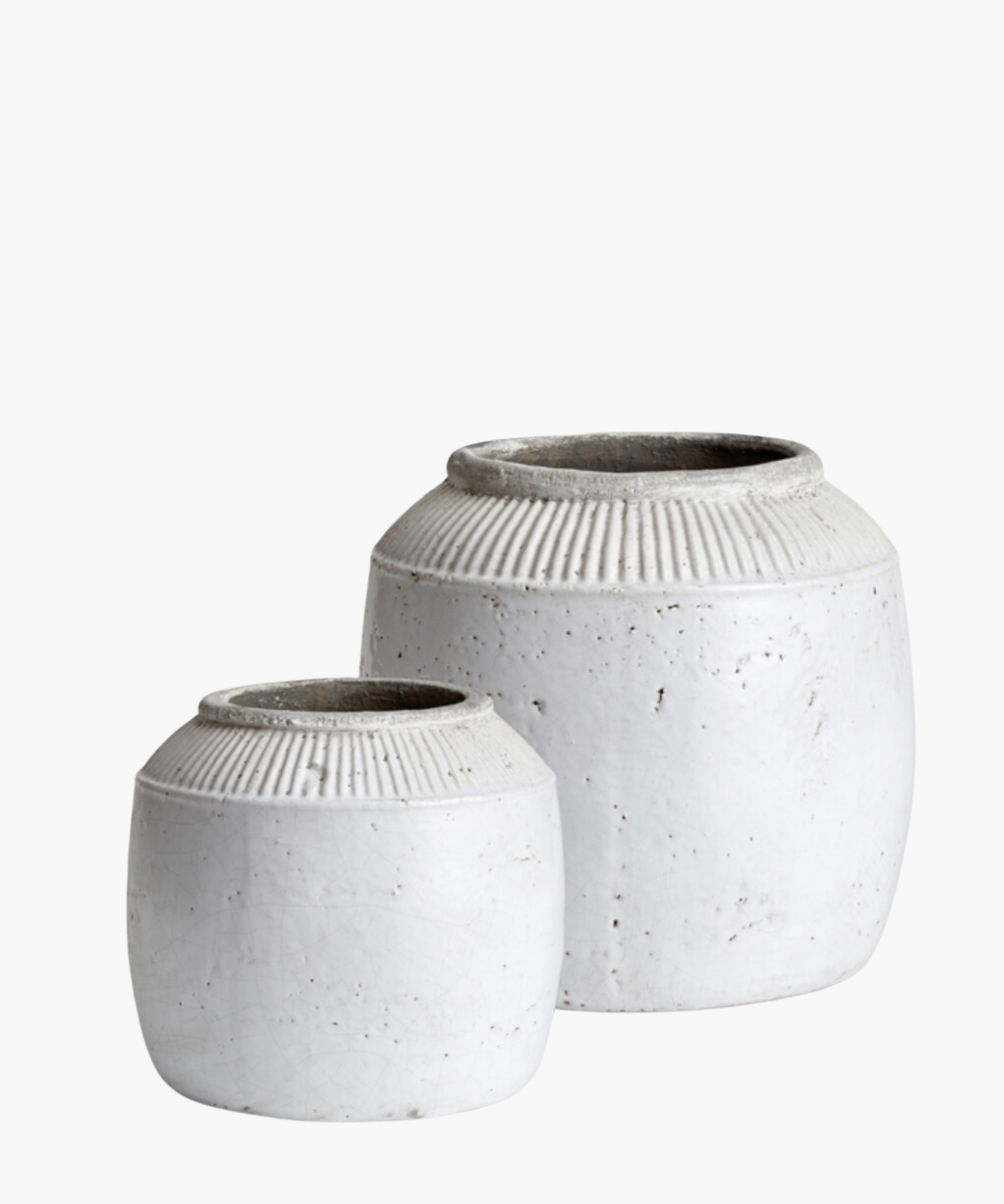 Textured white ceramic pots with a round body and a narrow opening in 2 sizes. The pots have subtle vertical ridges near the top. | Wildwood Home Co.