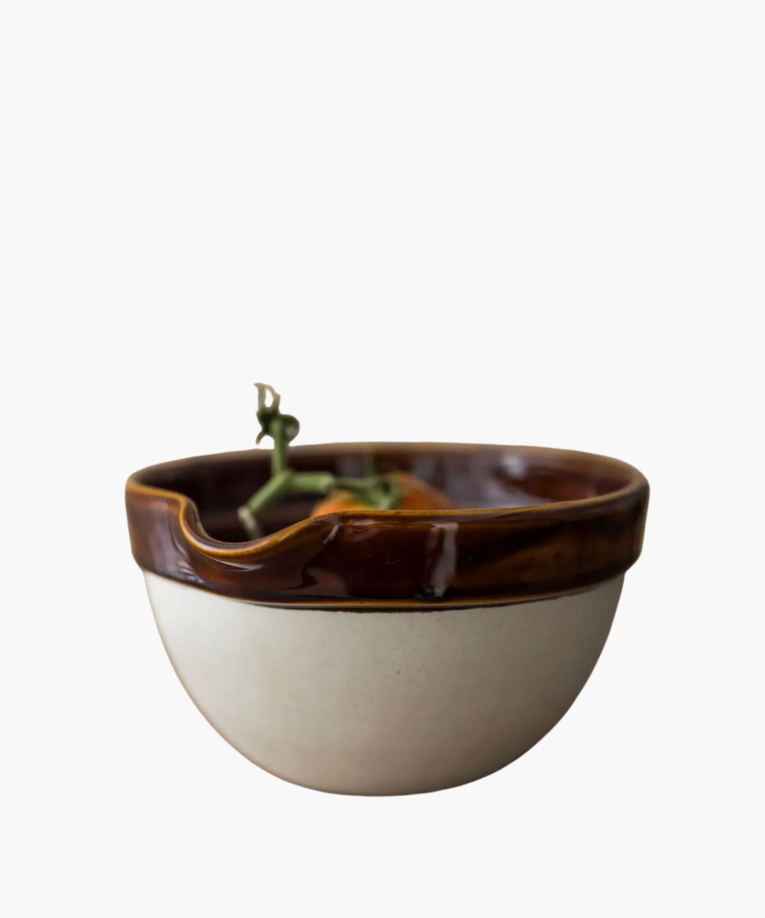 A ceramic bowl with a glossy brown rim and matte beige exterior holds a ripe tomato on a vine. The design is rustic and visually pleasing. | Wildwood Home Co.
