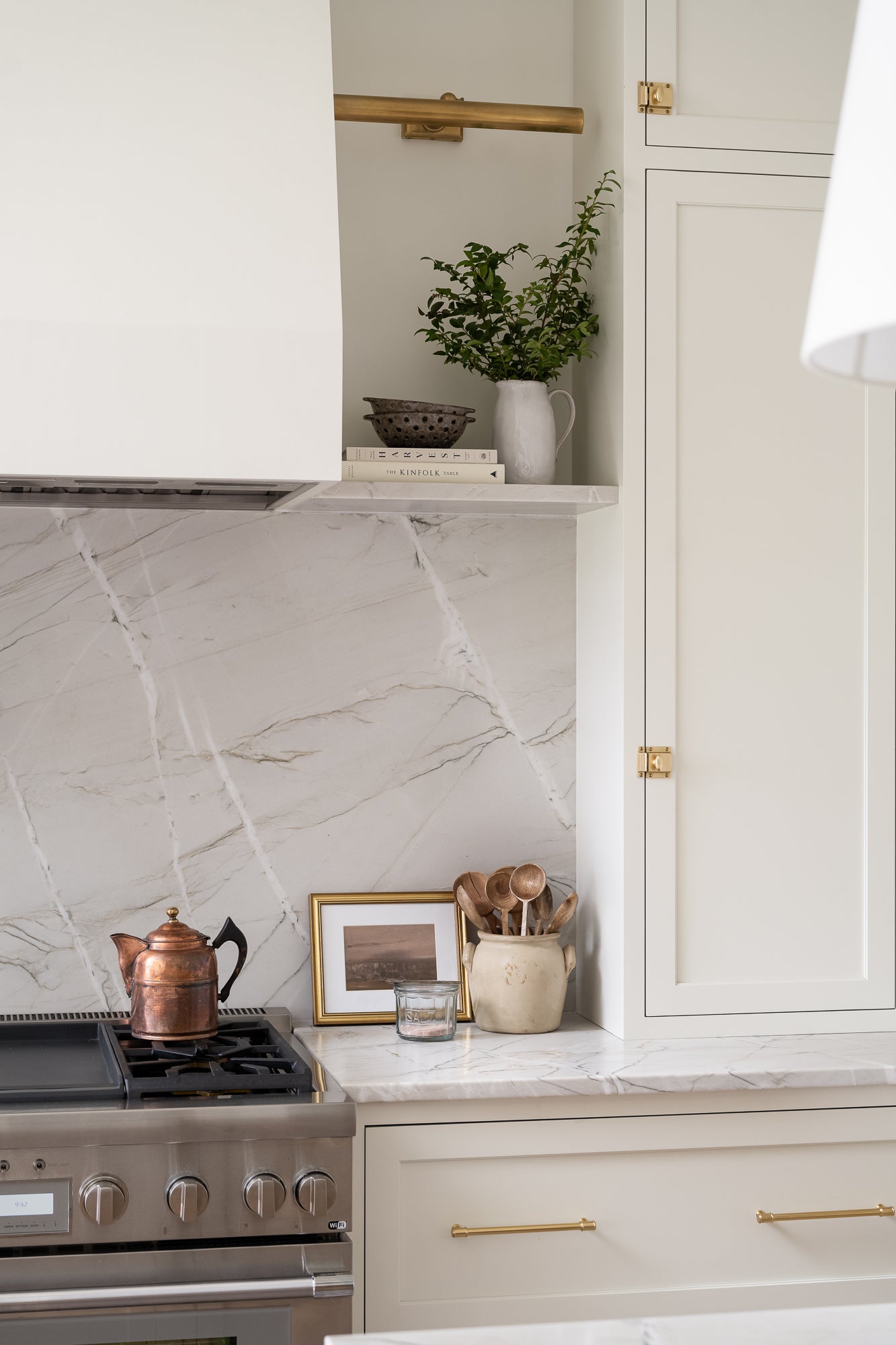 Ceramic colander or berry bowl with a rustic design, featuring a speckled brown glaze and evenly spaced holes. Styled in a simple neutral tone kitchen on a shelf with books. It conveys a handcrafted, earthy aesthetic. | Wildwood Home Co.