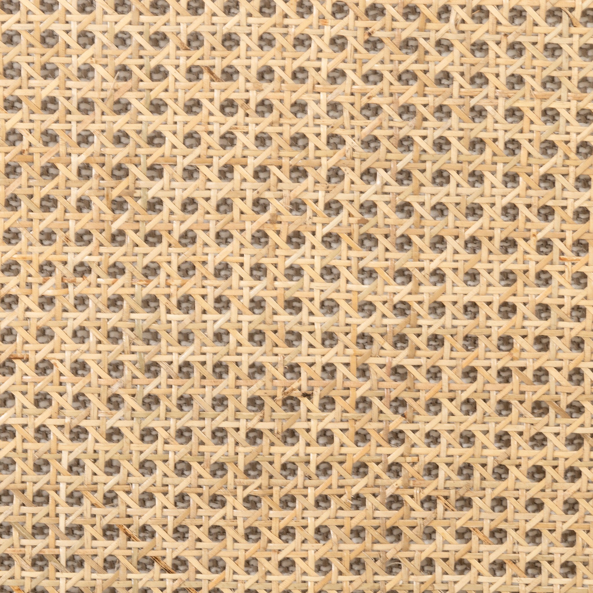 Close up of a beige armchair with dark metal legs on a white background.