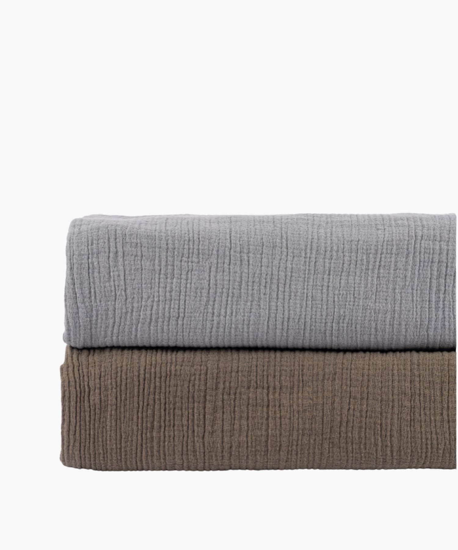 Two folded cotton duvet covers in warm taupe and grey stacked together showing color contrast and soft crinkle texture.