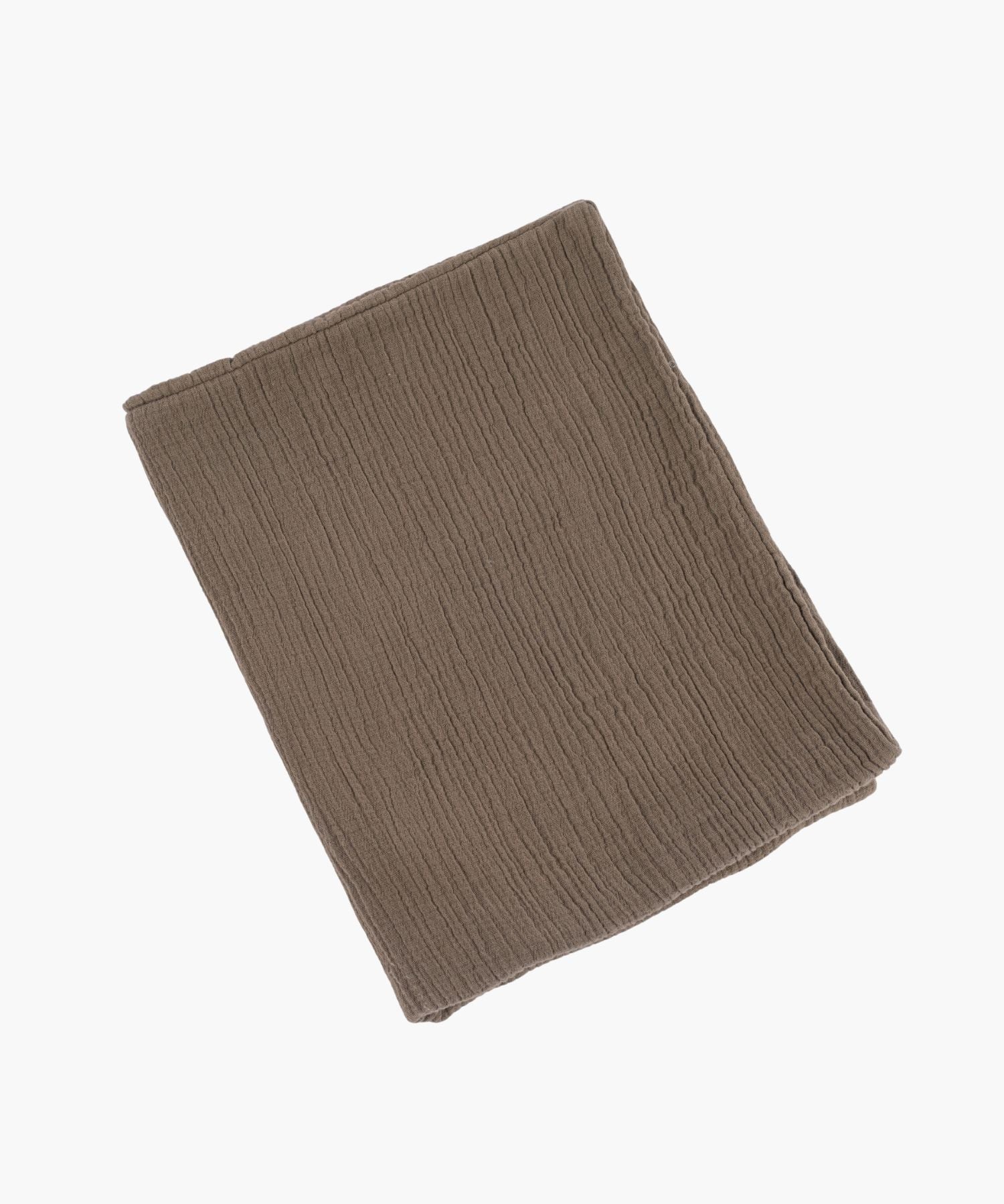 Folded cotton duvet cover in warm taupe with a soft crinkle texture and knife edge finish, offering a minimal, airy feel.