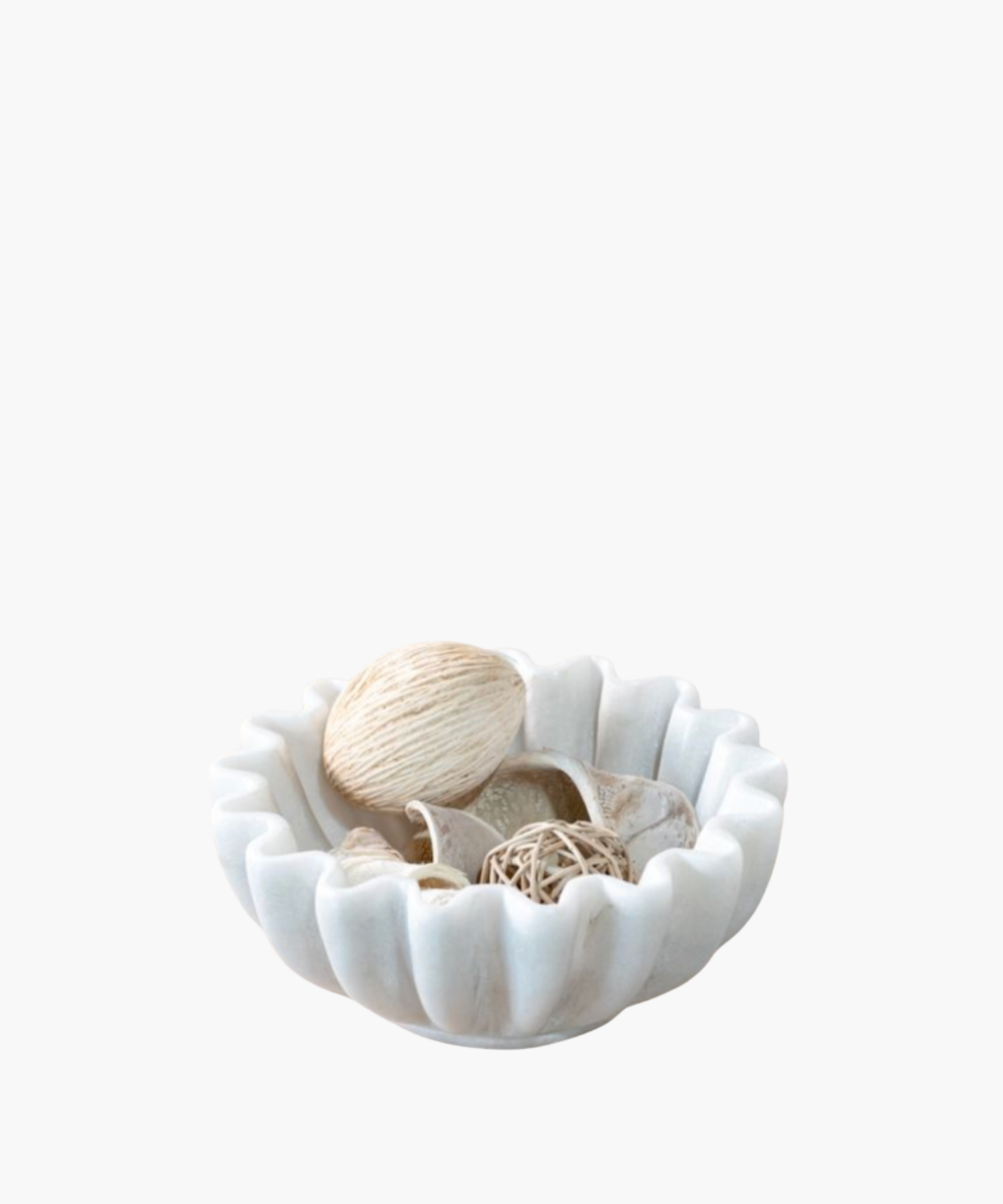 A scalloped cream ceramic bowl holds natural decorative items, including a string-wrapped ball, rattan orb, and seashells, conveying a calm, coastal vibe. | Wildwood Home Co.