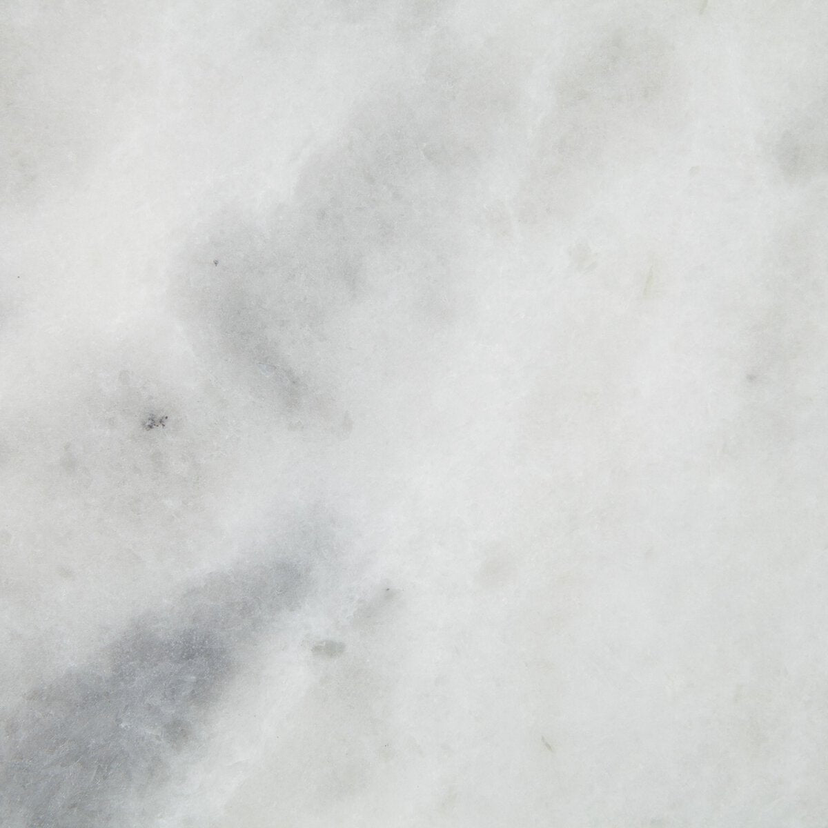 Close-up of a light gray marble table top showi the stones pattern and texture.