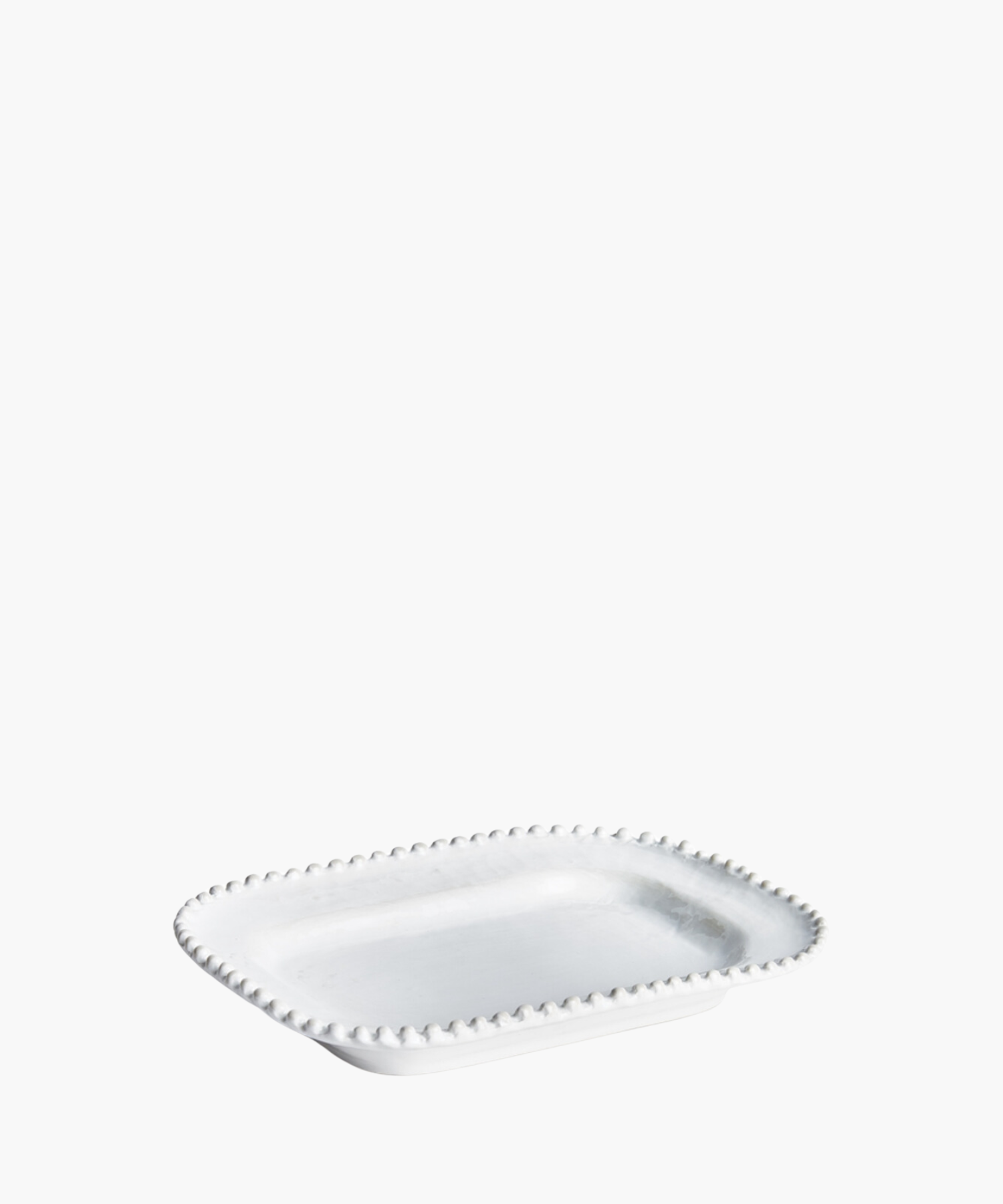 A rectangular, white ceramic plate with a beaded edge design is displayed on a plain white background, conveying a sense of elegance and simplicity.