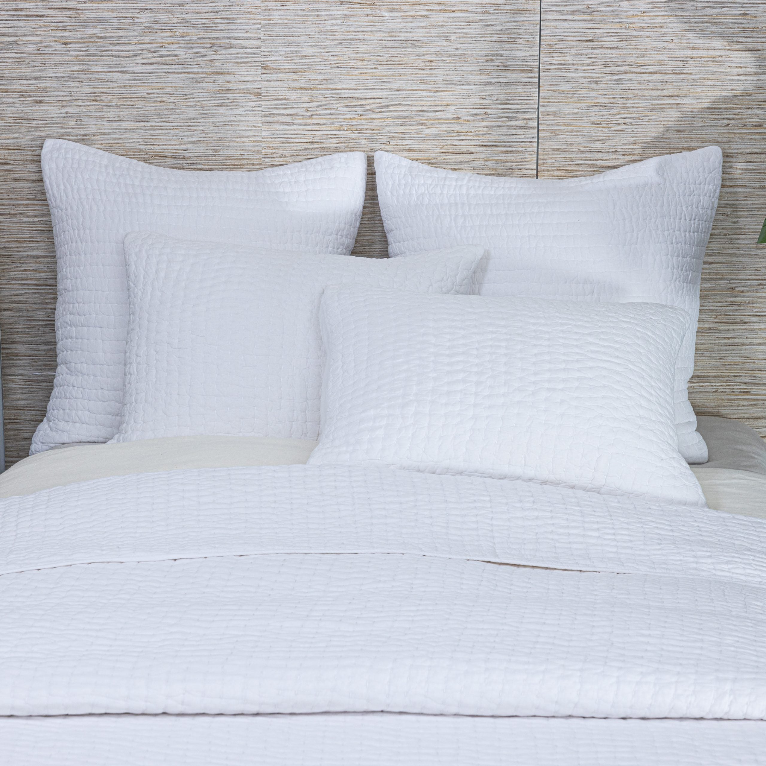 Styled Maegan Quilt on a bed, layered with matching shams and pillows, emphasizing its artisanal stitching and soft drape. | Wildwood Home Co.