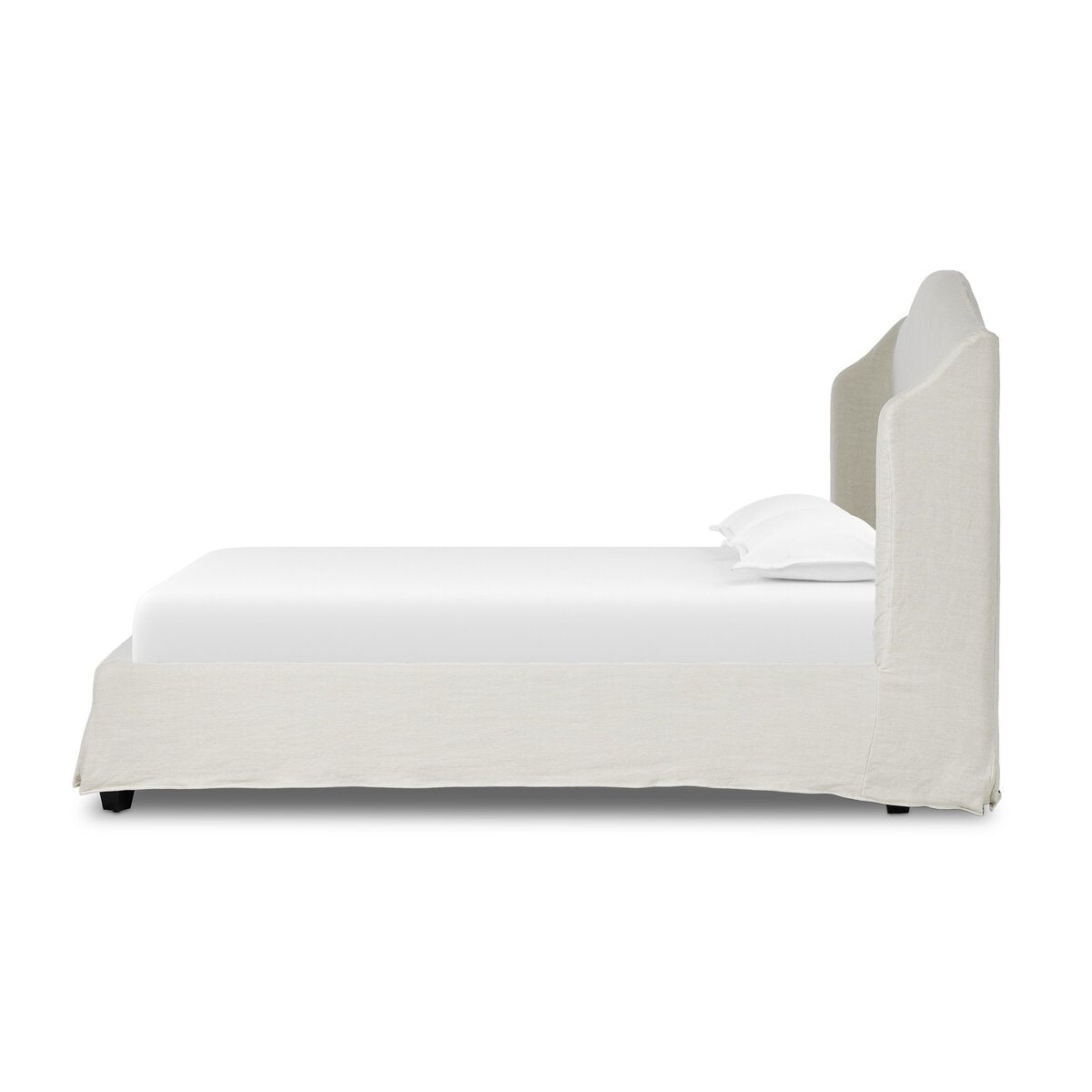 Side profile of a white bed with a matching headboard on a white background.