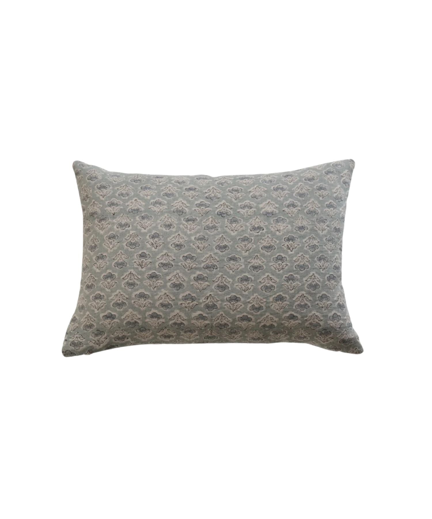 A rectangular or lumbar pillow with a subtle, intricate floral pattern in muted blue and gray tones. The design is elegant, conveying a calm and cozy atmosphere.