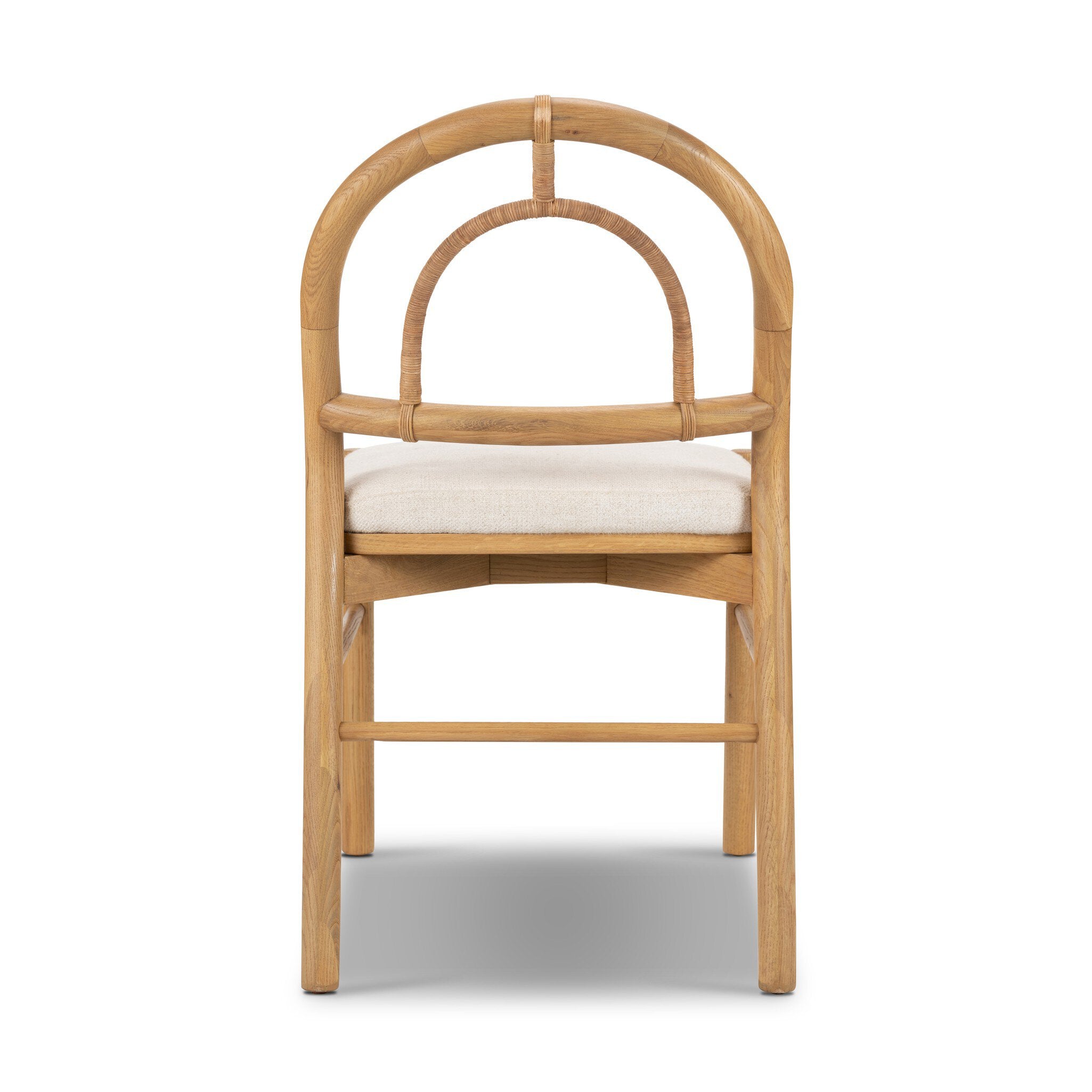 The back of a solid oak dining chair with an arched frame, hand-wrapped cane back detailing, and an upholstered drop-in seat.