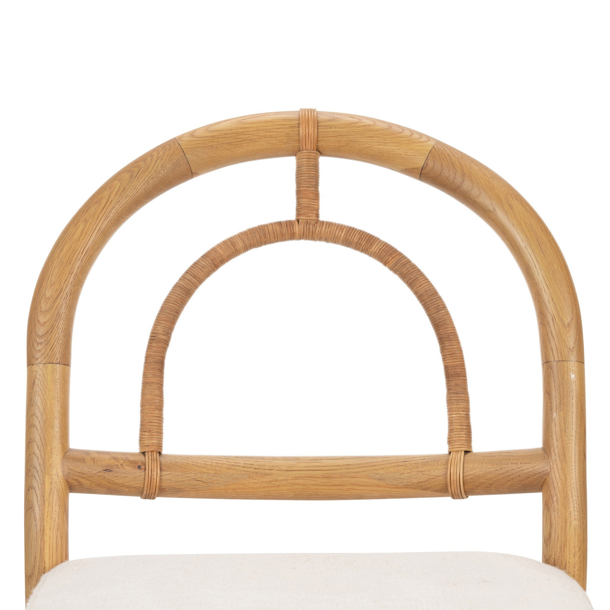 The back of a solid oak dining chair with an arched frame, hand-wrapped cane back detailing, and an upholstered drop-in seat.