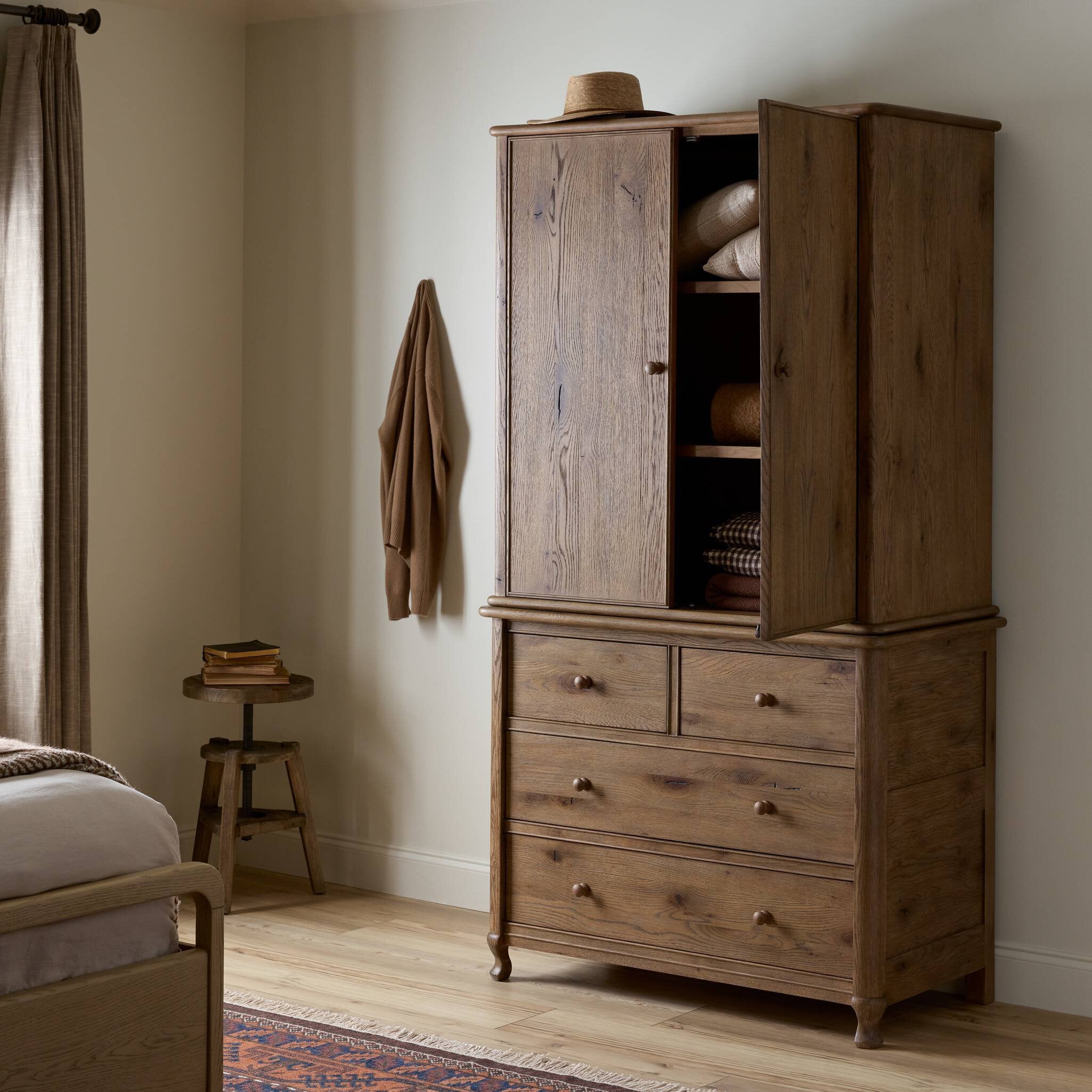 Wooden armoire with open doors in a bedroom setting. | Wildwood Home Co.