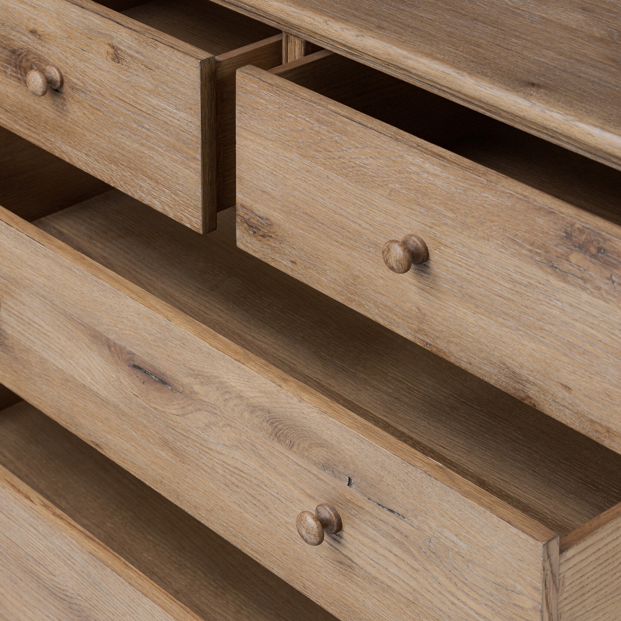 Close-up of a wooden dresser with open drawers.