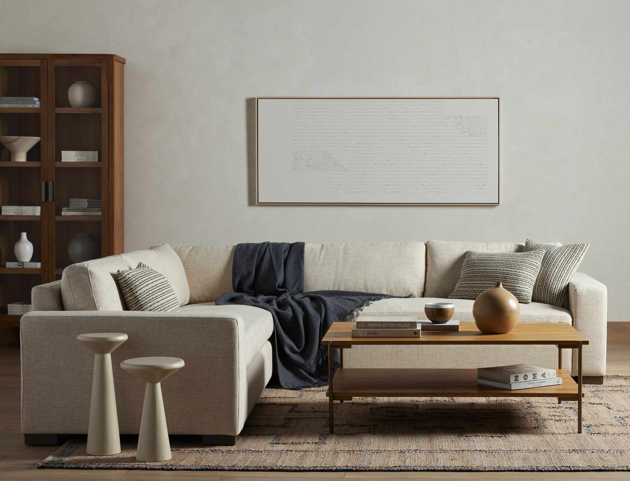 Modern living room with a beige sectional sofa, wooden coffee table, and decorative items.