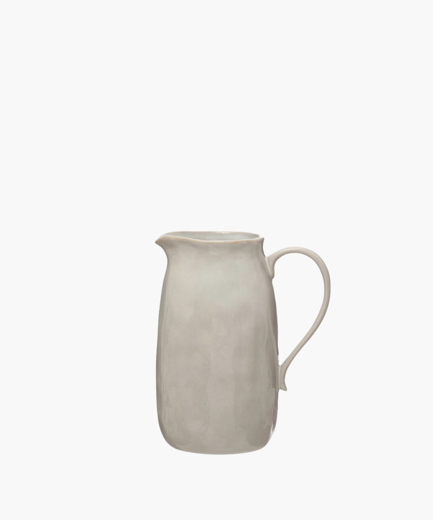 A simple, elegant beige ceramic pitcher with a smooth curved handle and a subtly textured surface, evoking a minimalist and classic design. | Wildwood Home Co.