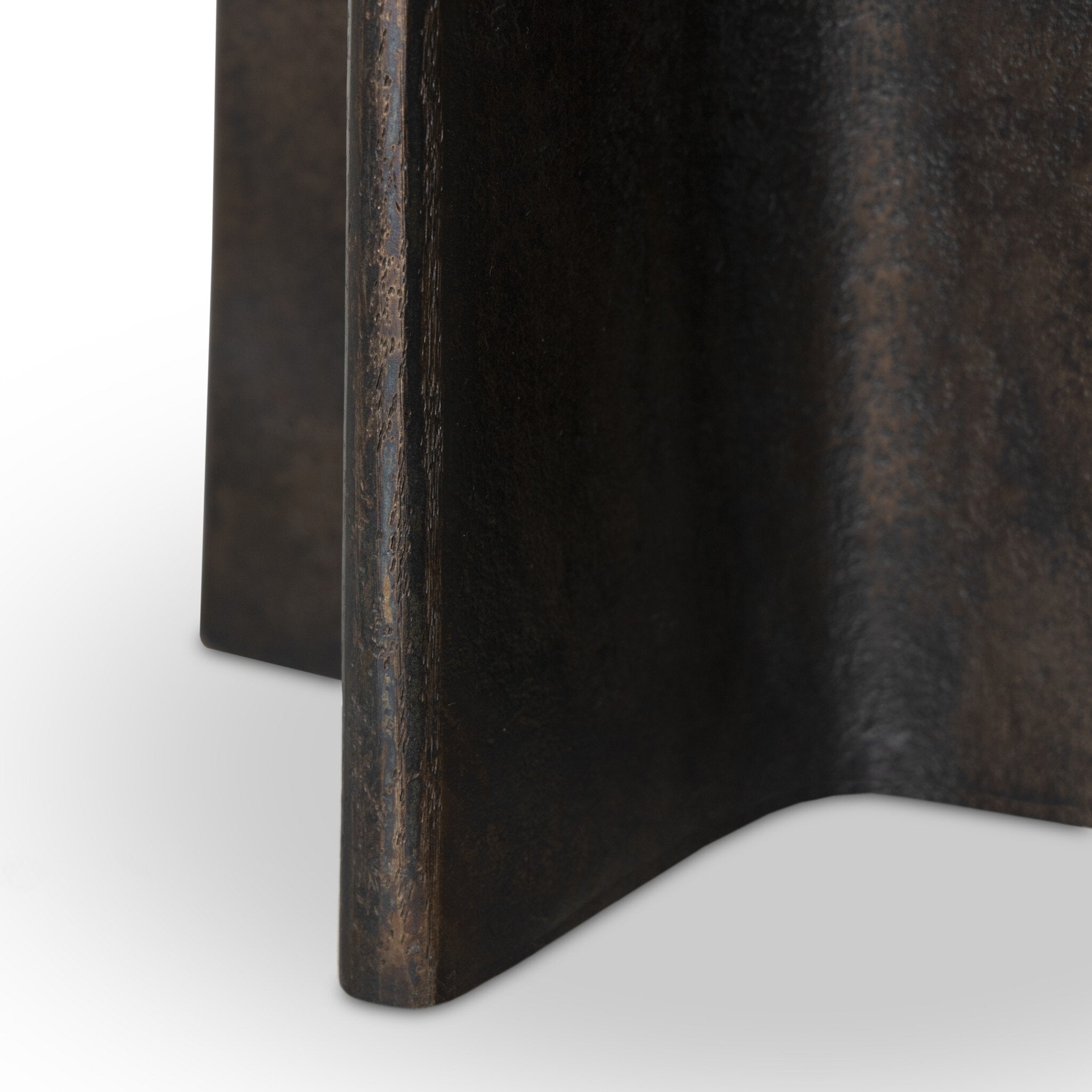 Close up picture of the X-shaped base with a distressed bronze finish.