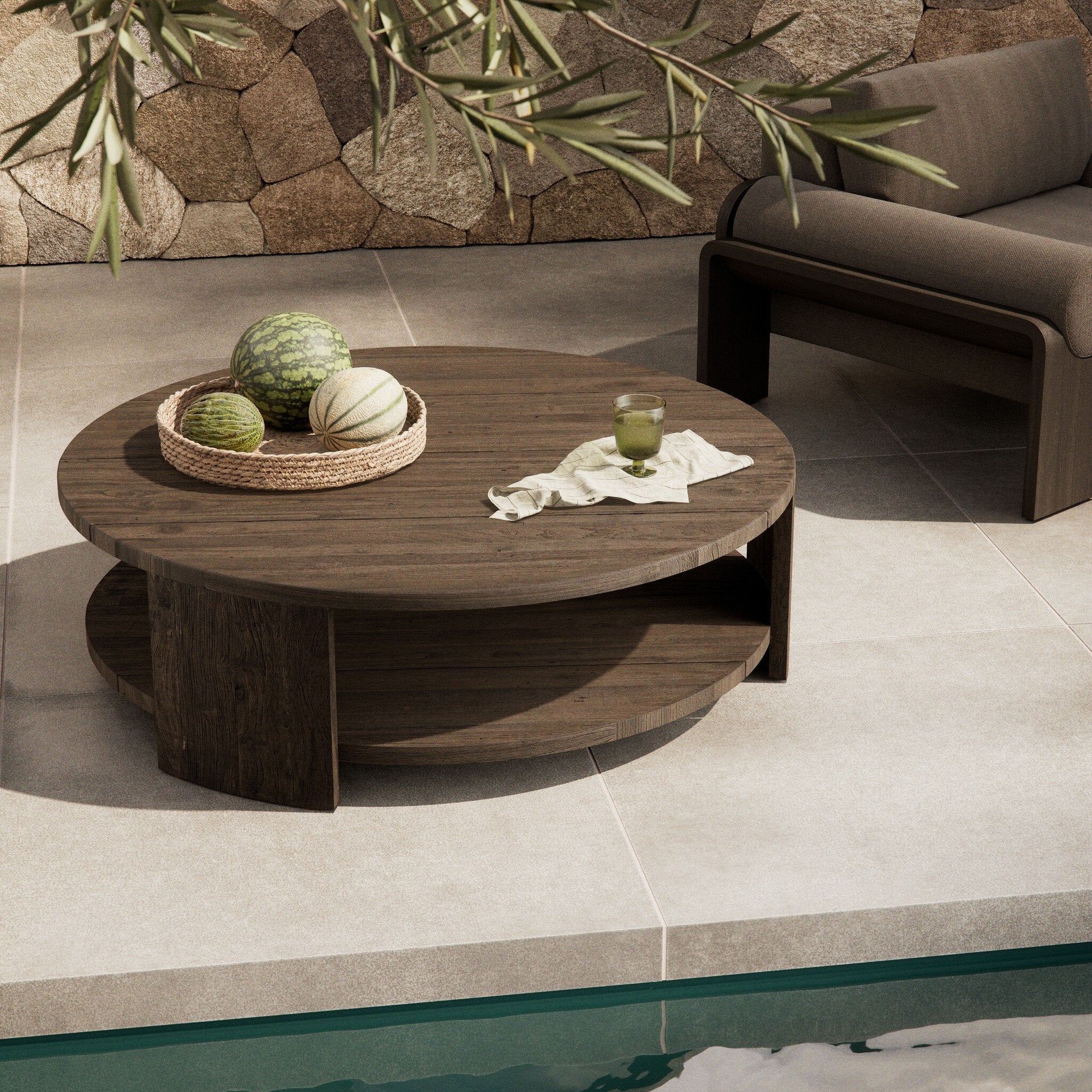 Round wooden coffee table with decorative items on a patio area. | Wildwood Home Co.