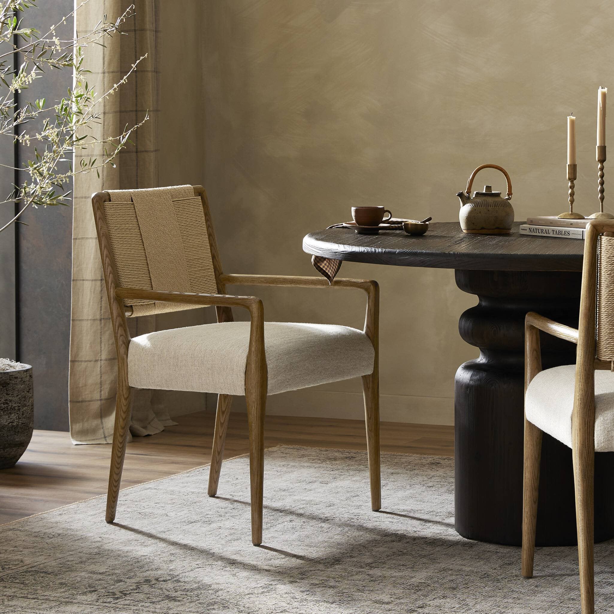 Dining room with a dark wooden table and beige chairs against a neutral wall. | Wildwood Home Co.