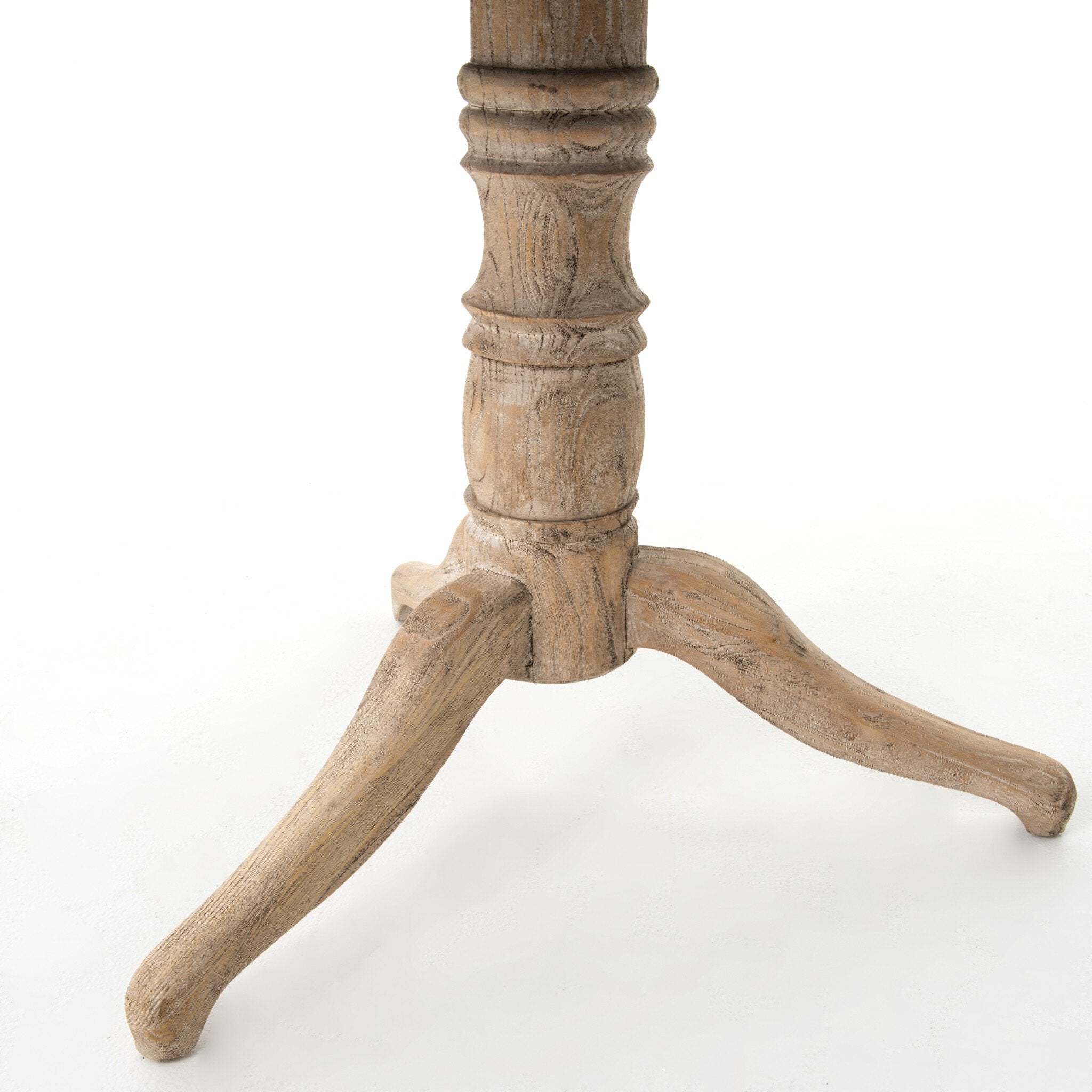 Close up picture of the turned pedestal and curved tripod feet on a white background feet. | Wildwood Home Co.