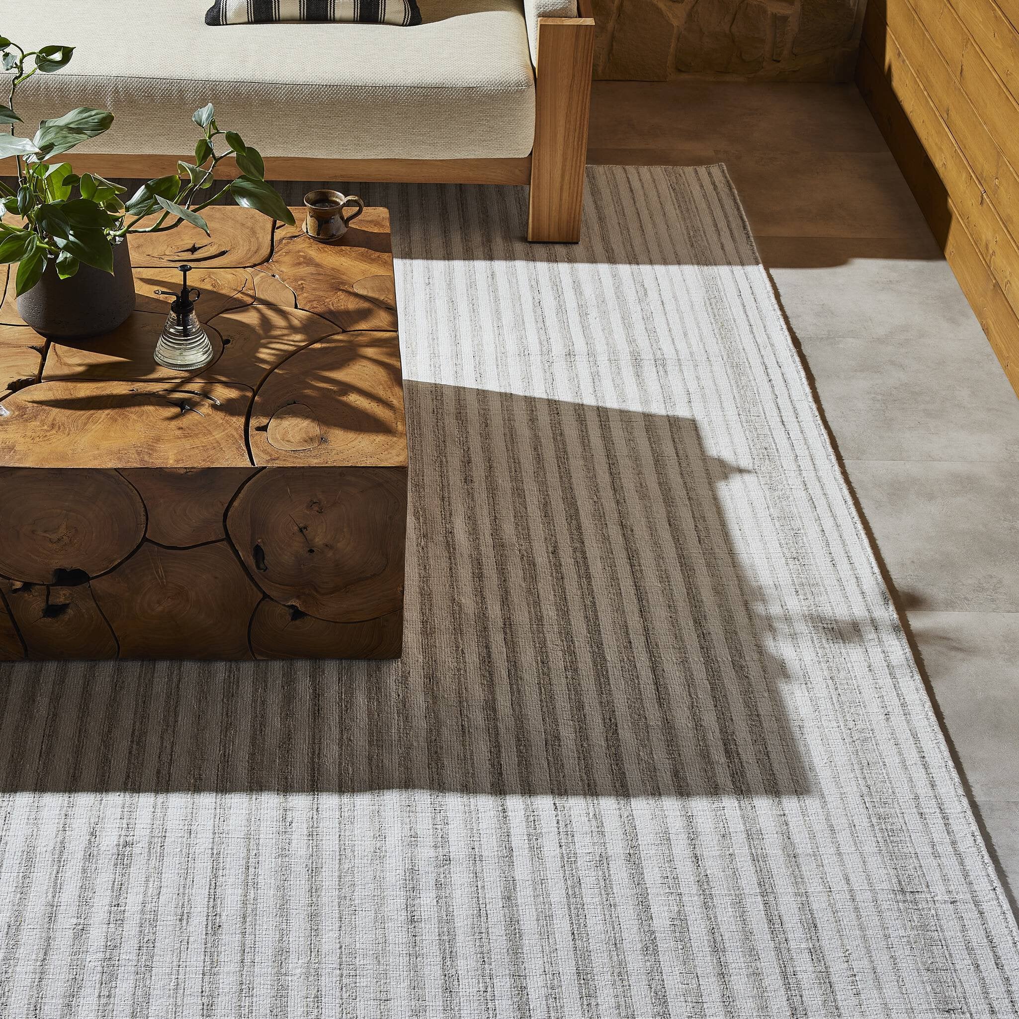 Rectangular outdoor rug with a striped pattern on a white background.