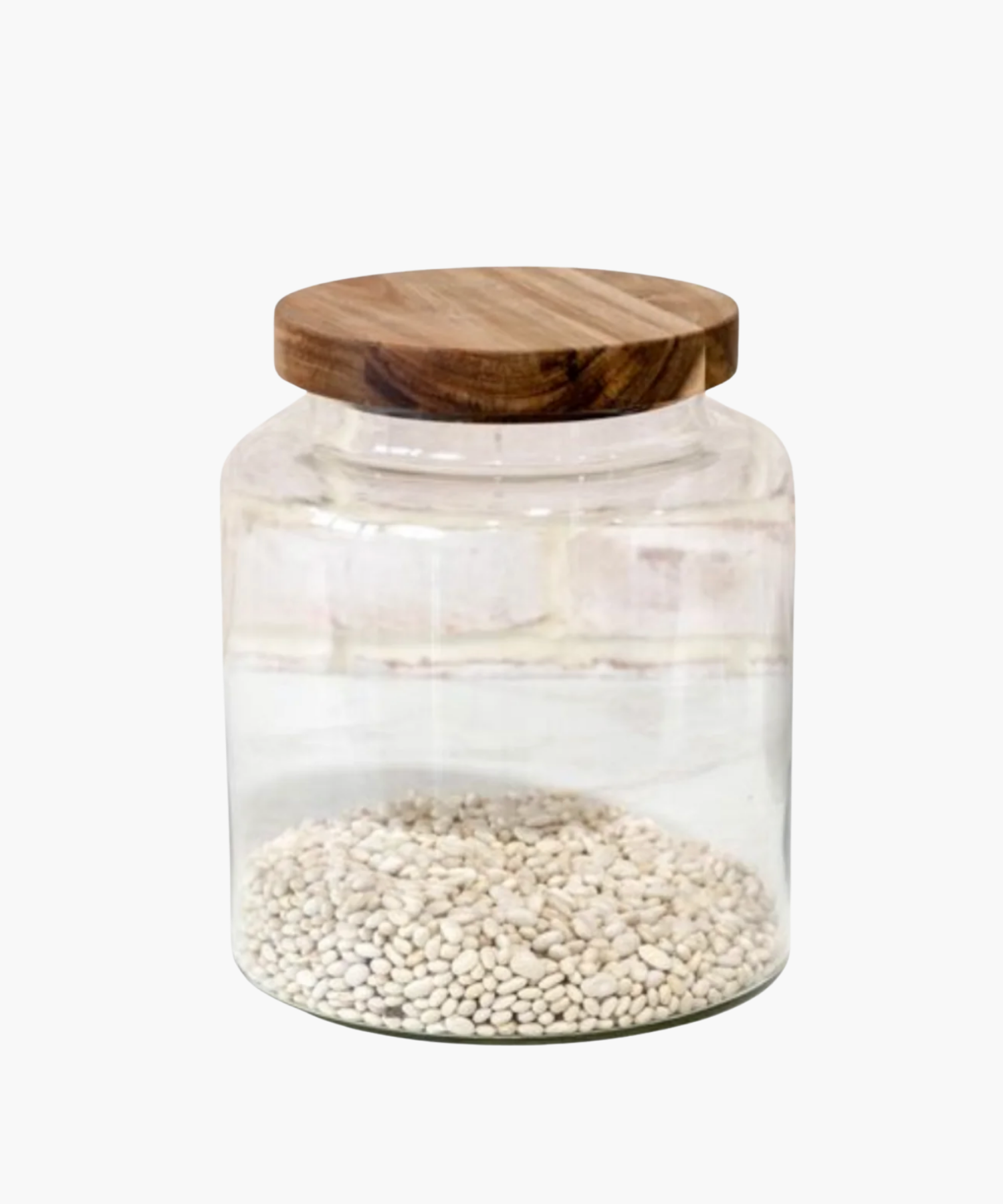 A large clear glass jar with a wooden lid, filled with dried white beans. The clean, minimalist design conveys a rustic, cozy feel. | Wildwood Home Co.