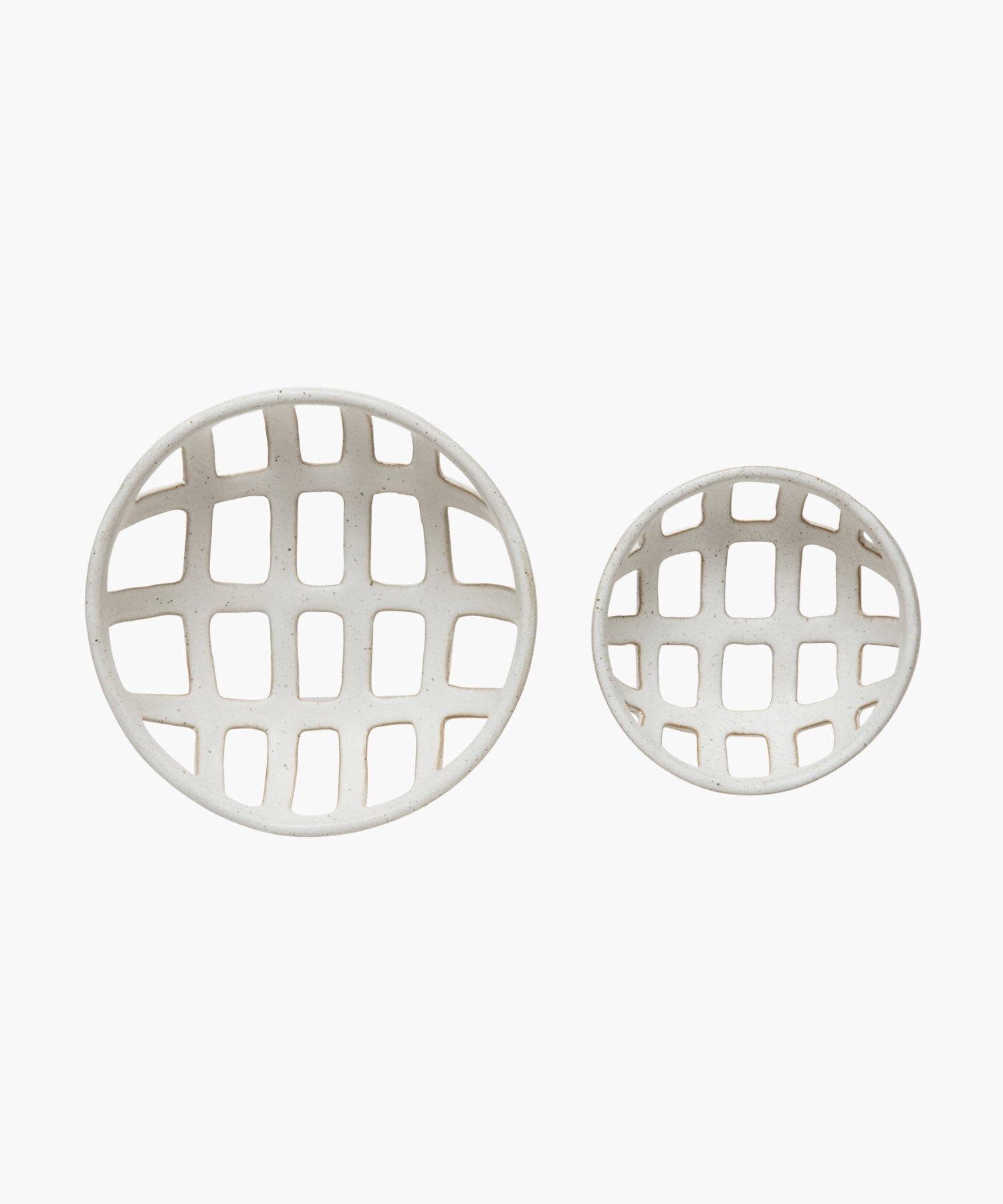 Overhead view of two openwork stoneware ceramic bowls with a white reactive glaze finish, one larger than the other, featuring an airy, lattice-like design. The tone is minimalist and modern. | Wildwood Home Co.