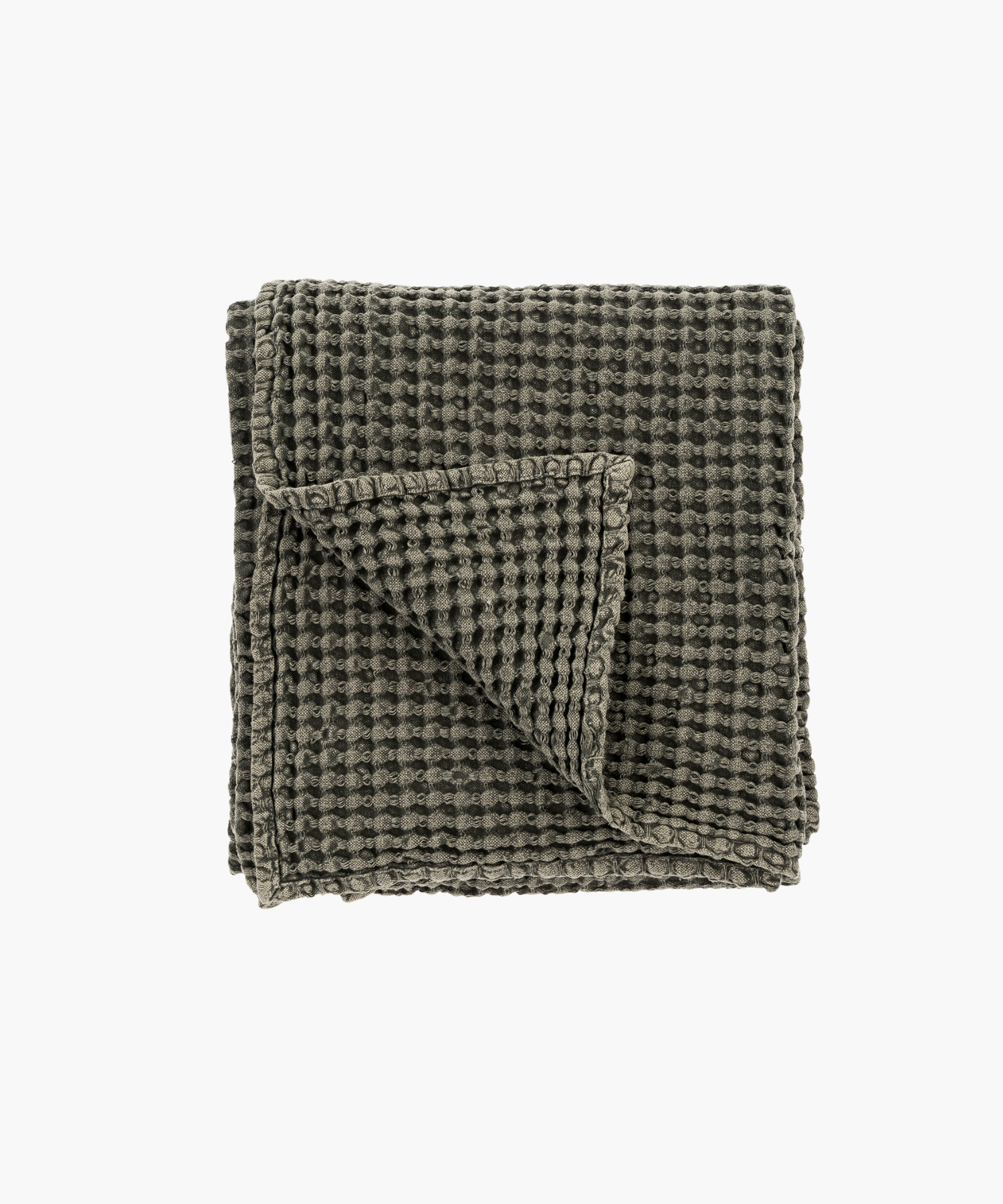 Dark gray or charcoal waffle weave throw blanket, neatly folded with one corner flipped over, showcasing its textured, cozy fabric on a plain white background. | Wildwood Home Co.