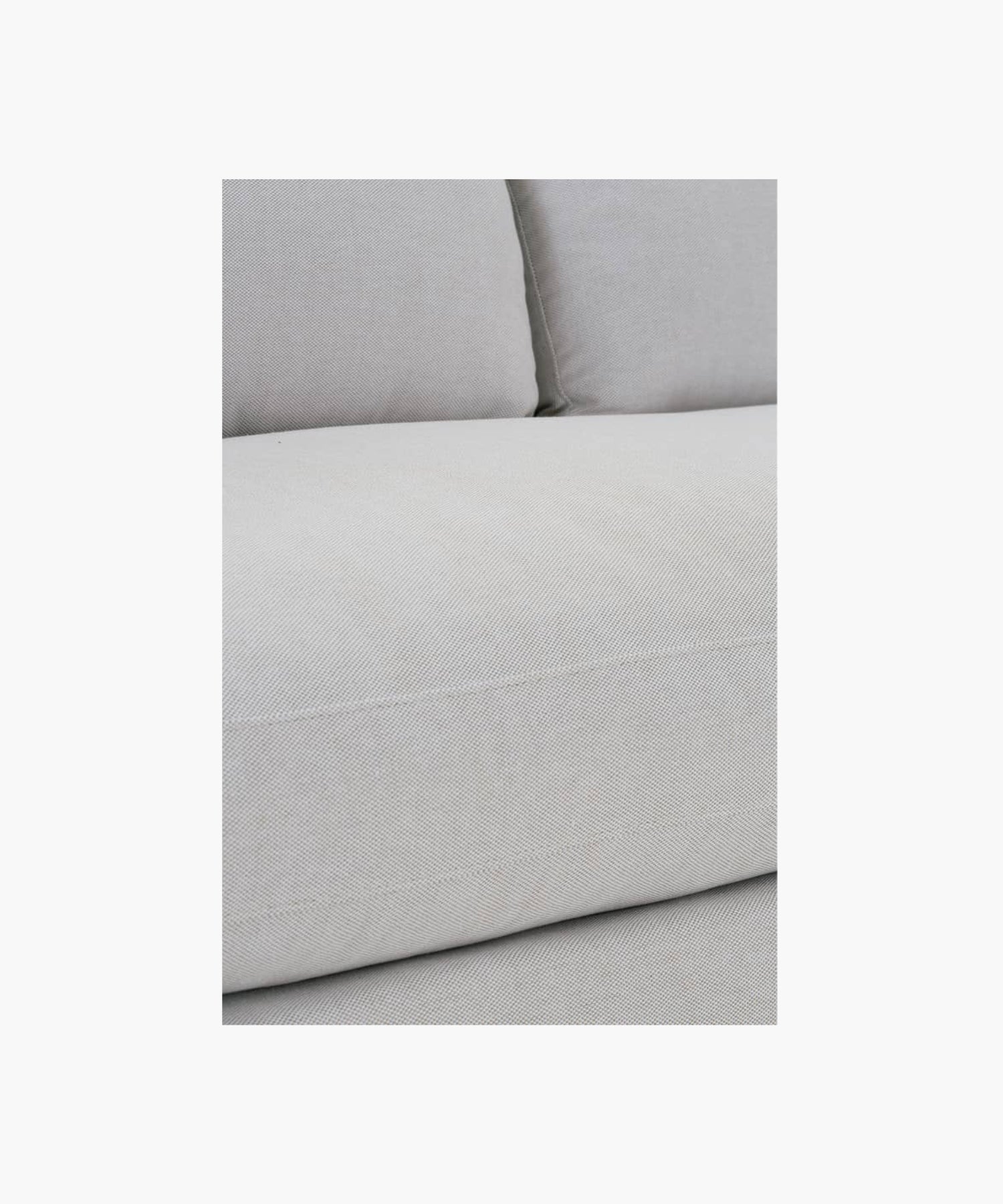 Close up of a gray sofa on a white background.