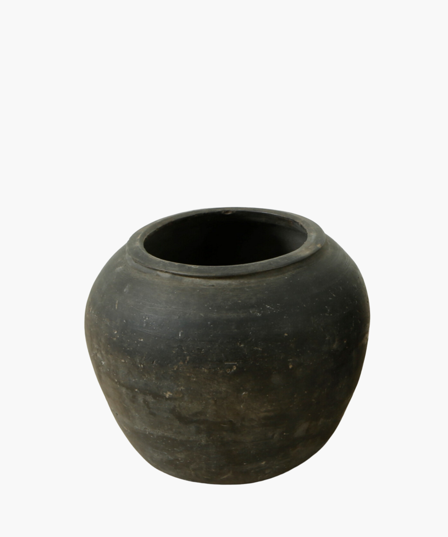A round, rustic black clay pot with a smooth, matte finish. The pot has a wide opening and subtle texture, conveying a simple, earthy feel. | Wildwood Home Co.