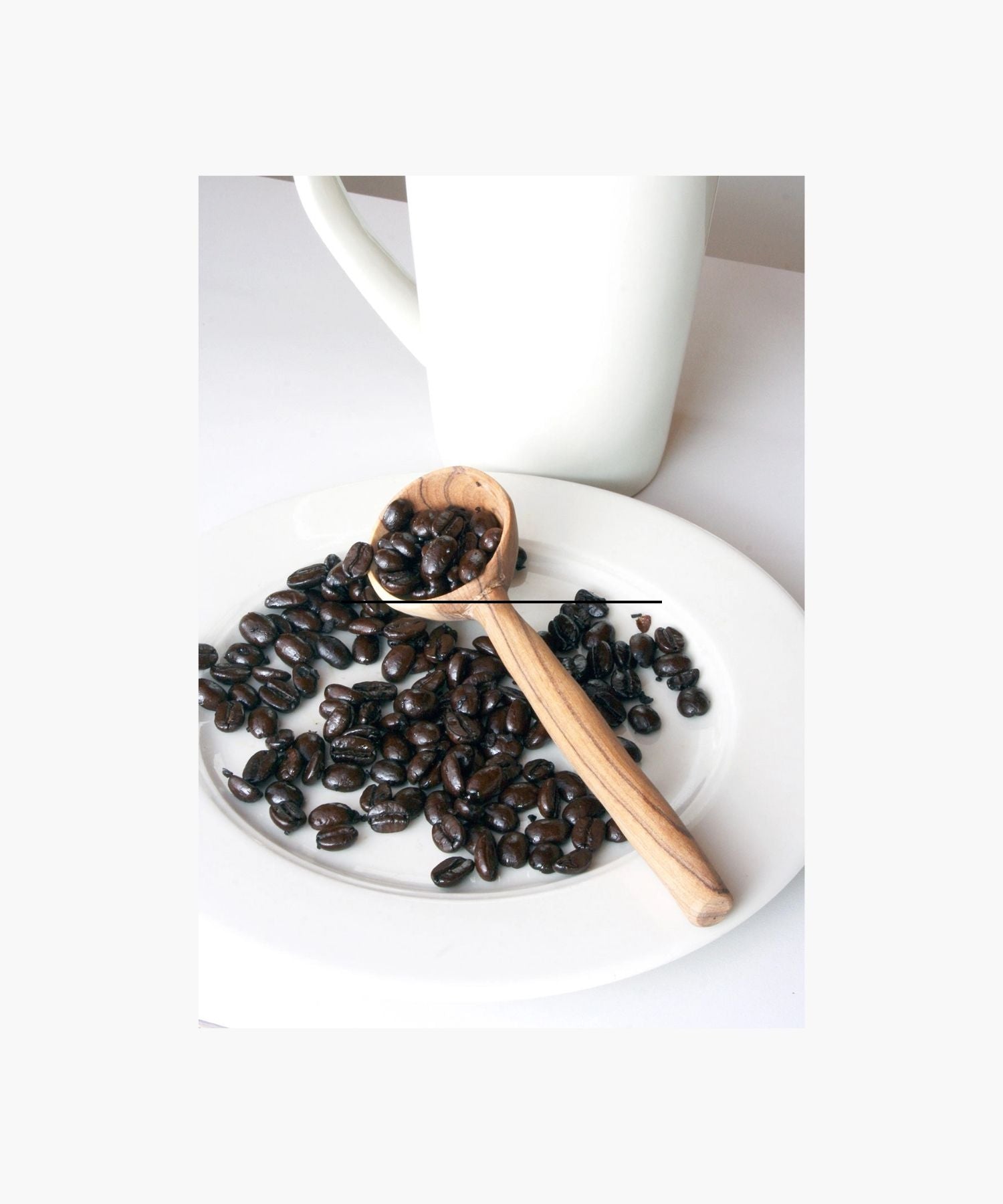 A wooden spoon with distinctive, dark grain patterns on light olive wood styled with coffee beans. The design gives a rustic, artisanal feel. | Wildwood Home Co.