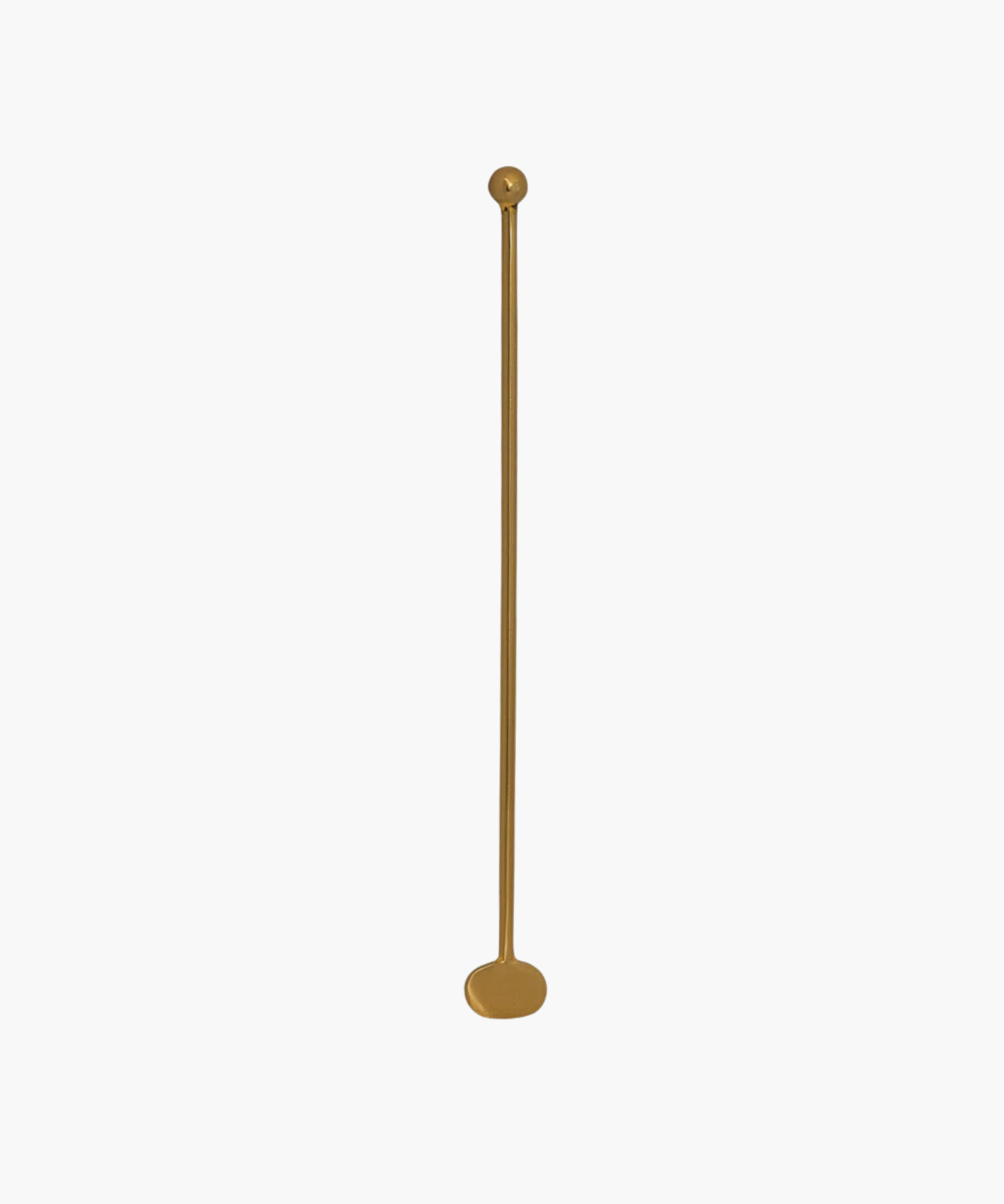 A long, slender brass cocktail stirrer with a rounded base and a small, spherical top placed against a plain white background. | Wildwood Home Co.
