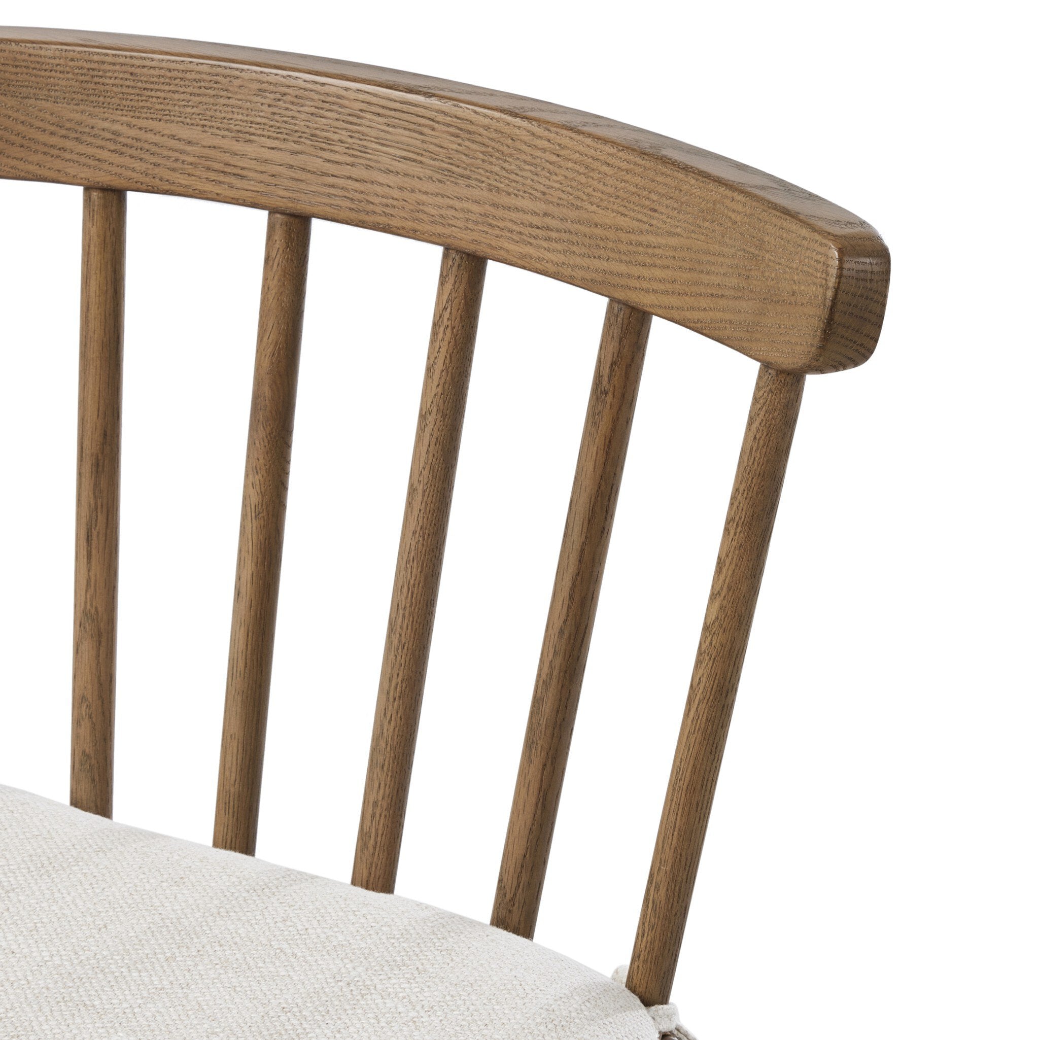 Close-up of a wooden chair with a white cushion on a white background