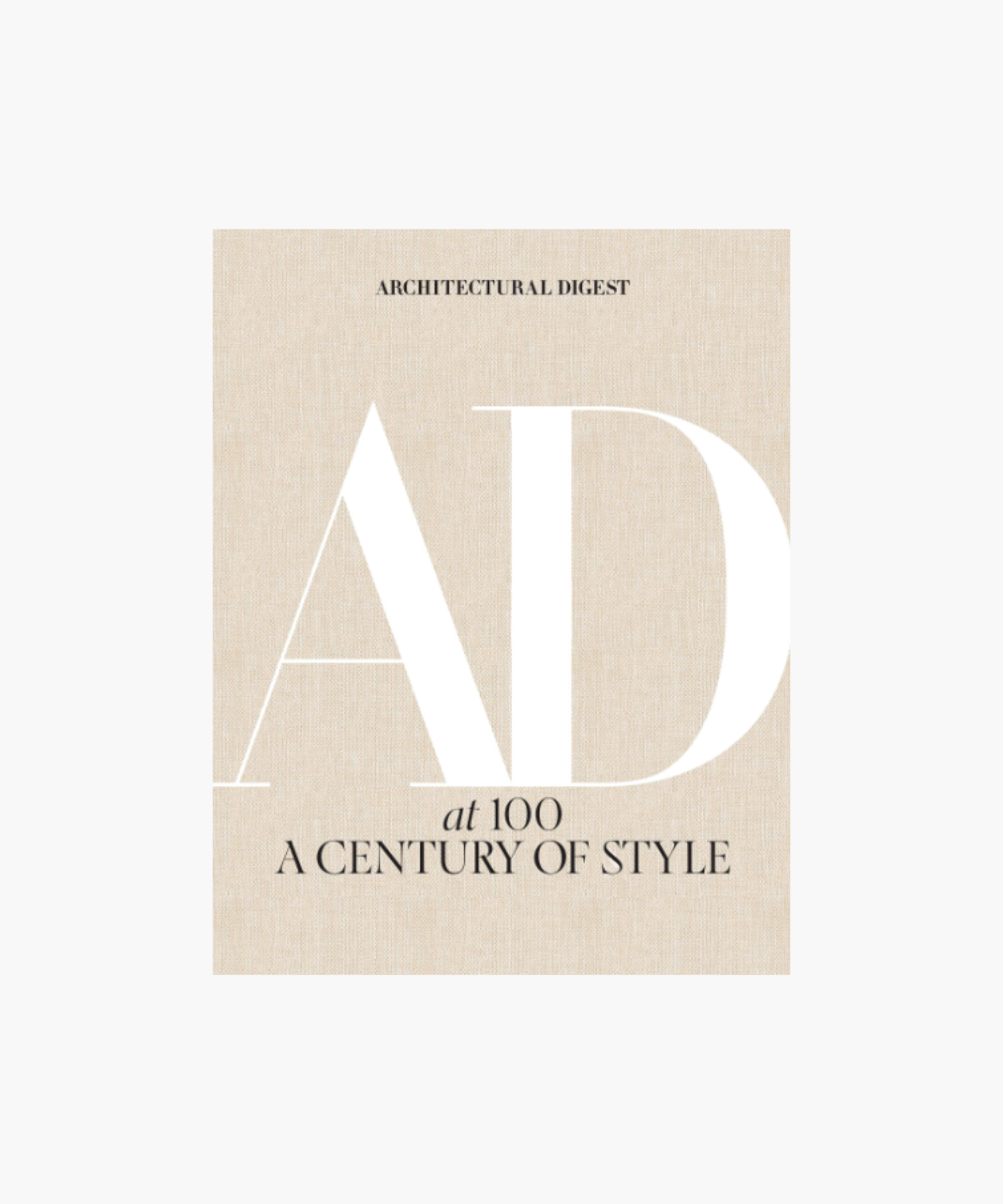 The cover of the book "Architectural Digest: AD at 100, A Century of Style" featuring large white "AD" letters on a textured beige background, conveying elegance. | Wildwood Home Co.